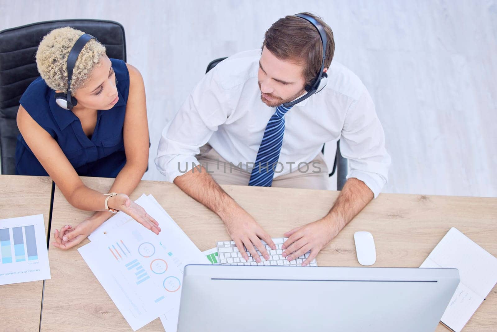 Call center, collaboration and overhead with a woman supervisor training a man employee in a telemarketing office. Customer care, teamwork and support with a female agent teaching a male colleague.