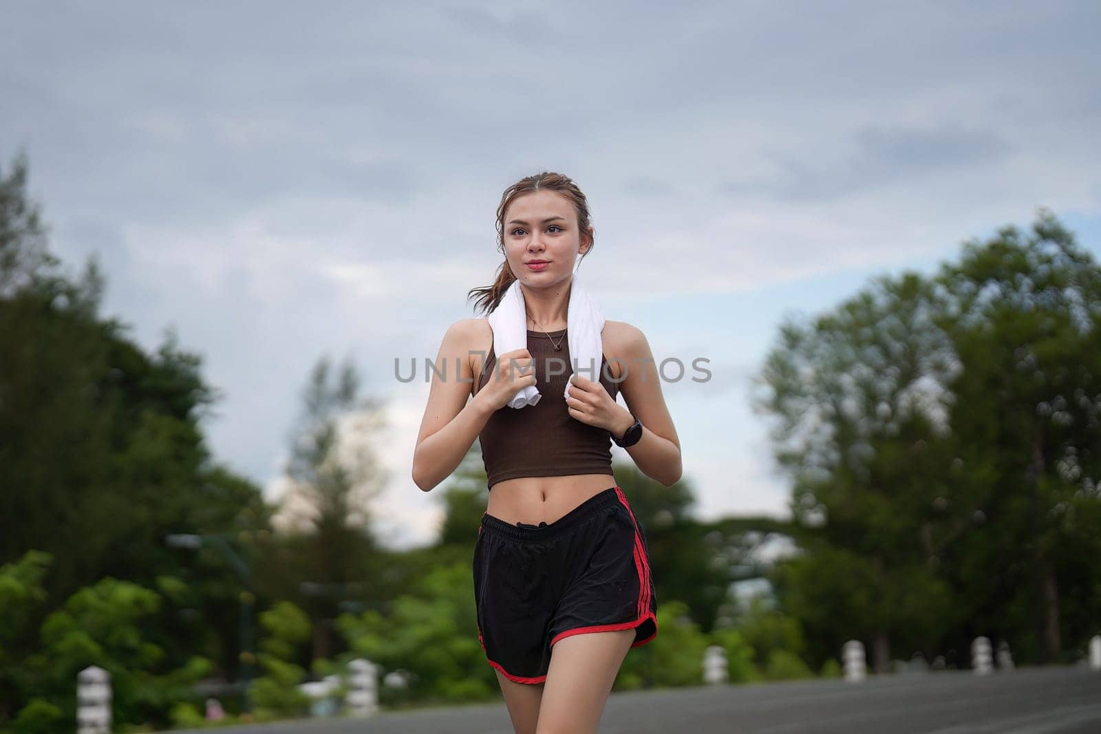 Young attractive beautiful athletic runner woman runs in the green park jogging. Healthy and active lifestyle concept.