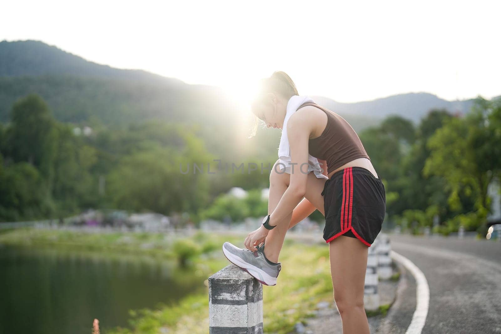 Running shoes. close up female athlete tying laces for jogging on road. Runner ties getting ready for training. Sport lifestyle. copy space.