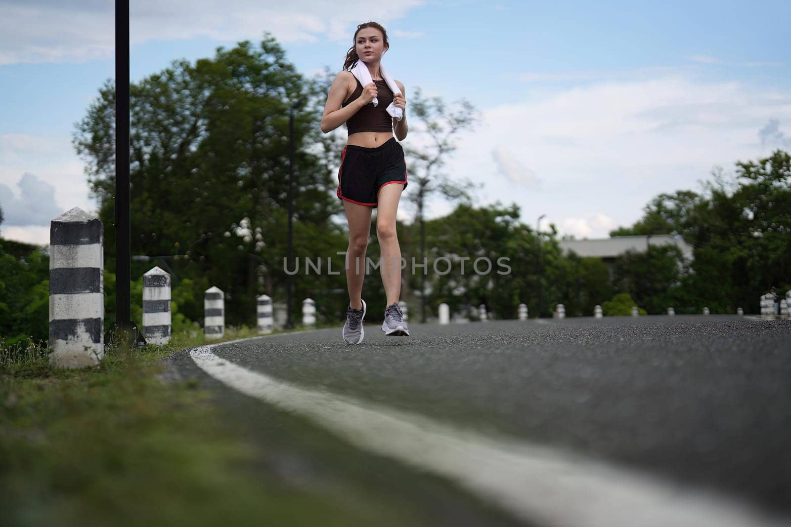 Young attractive beautiful athletic runner woman runs in the green park jogging. Healthy and active lifestyle concept.