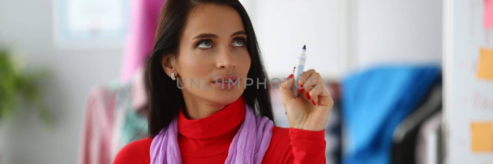 Portrait of pensive woman holding marker and looking up. Finding new ideas for business and thinking problem solutions concept