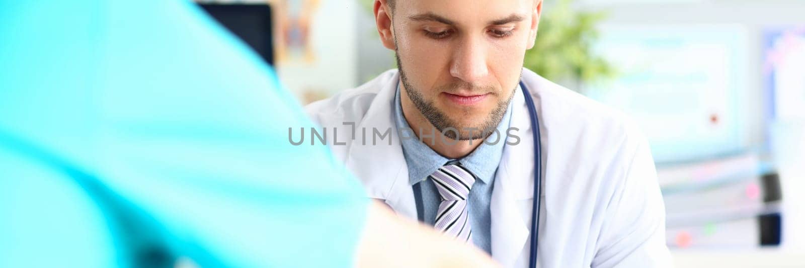 Doctor talks and listens to patient in clinic. Male conversation with urologist concept