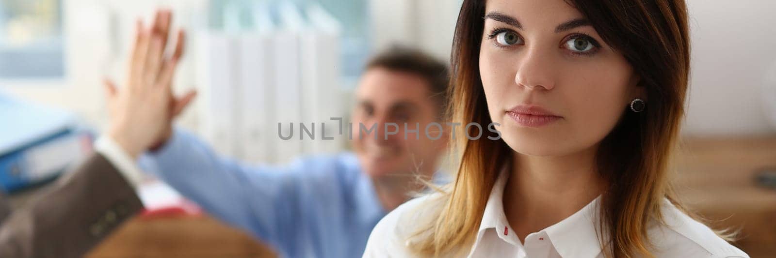 Sad dismissed woman against background of joyful colleagues partners in office. Stressed young lady having nervous breakdown after getting fired