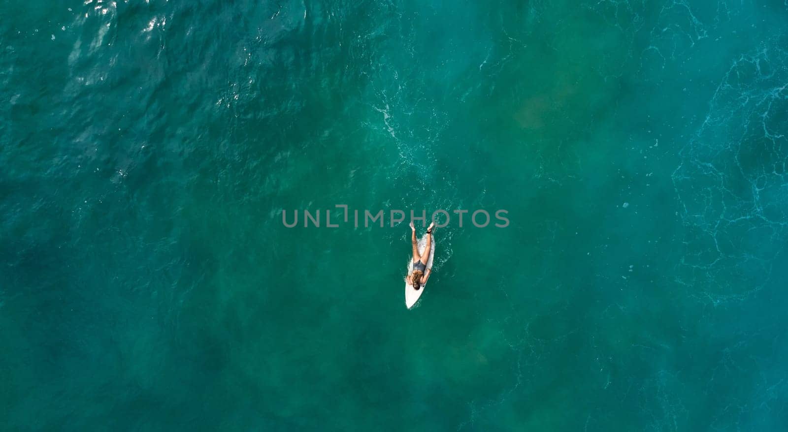 Aerial view of the ocean and surfer girl. by driver-s
