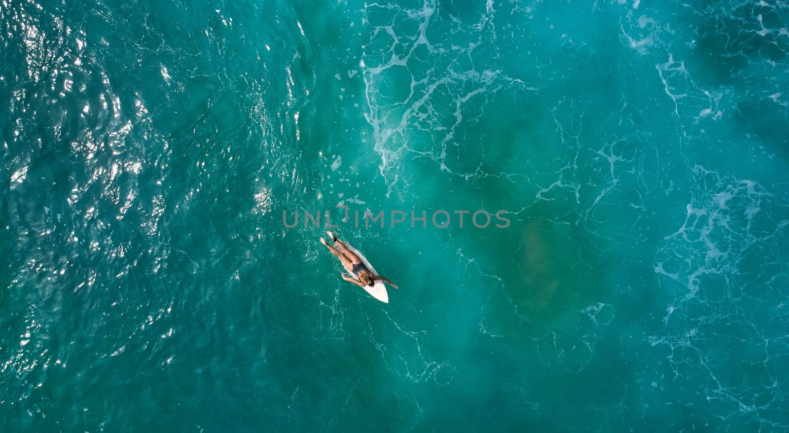 Aerial view of the ocean and surfer girl. by driver-s