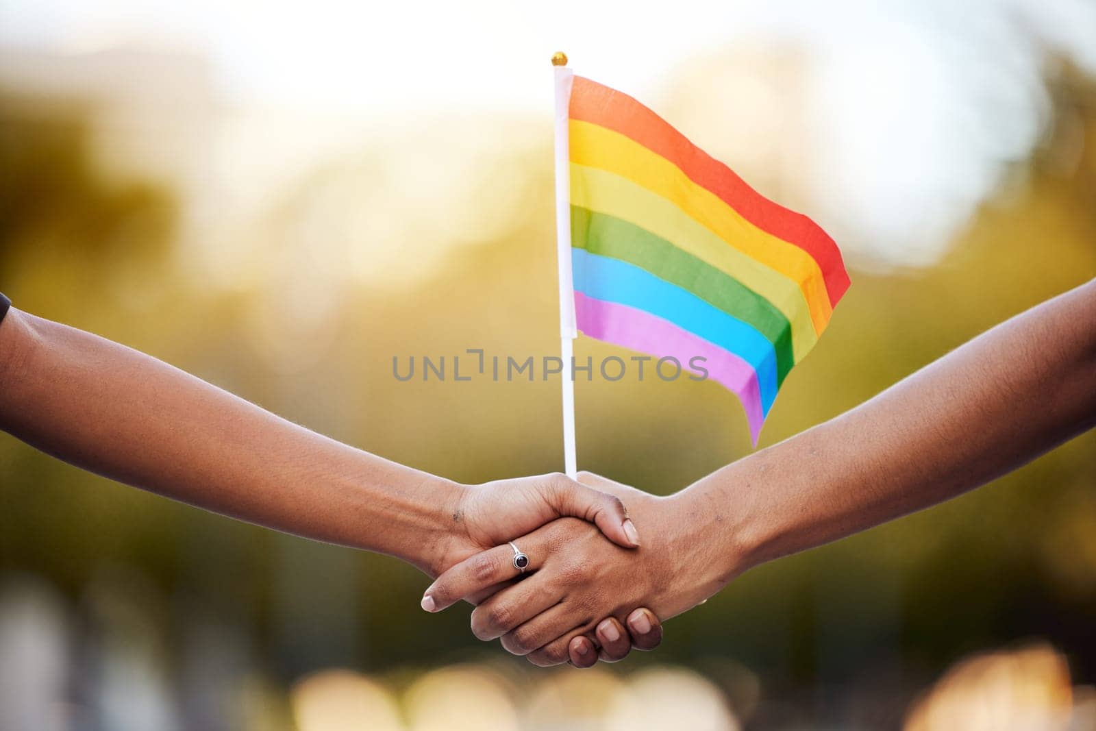LGBTQ rainbow, flag and couple holding hands for gay pride, lesbian support or human rights activist. Transgender, love and African black people together for equality, partnership and LGBT community.