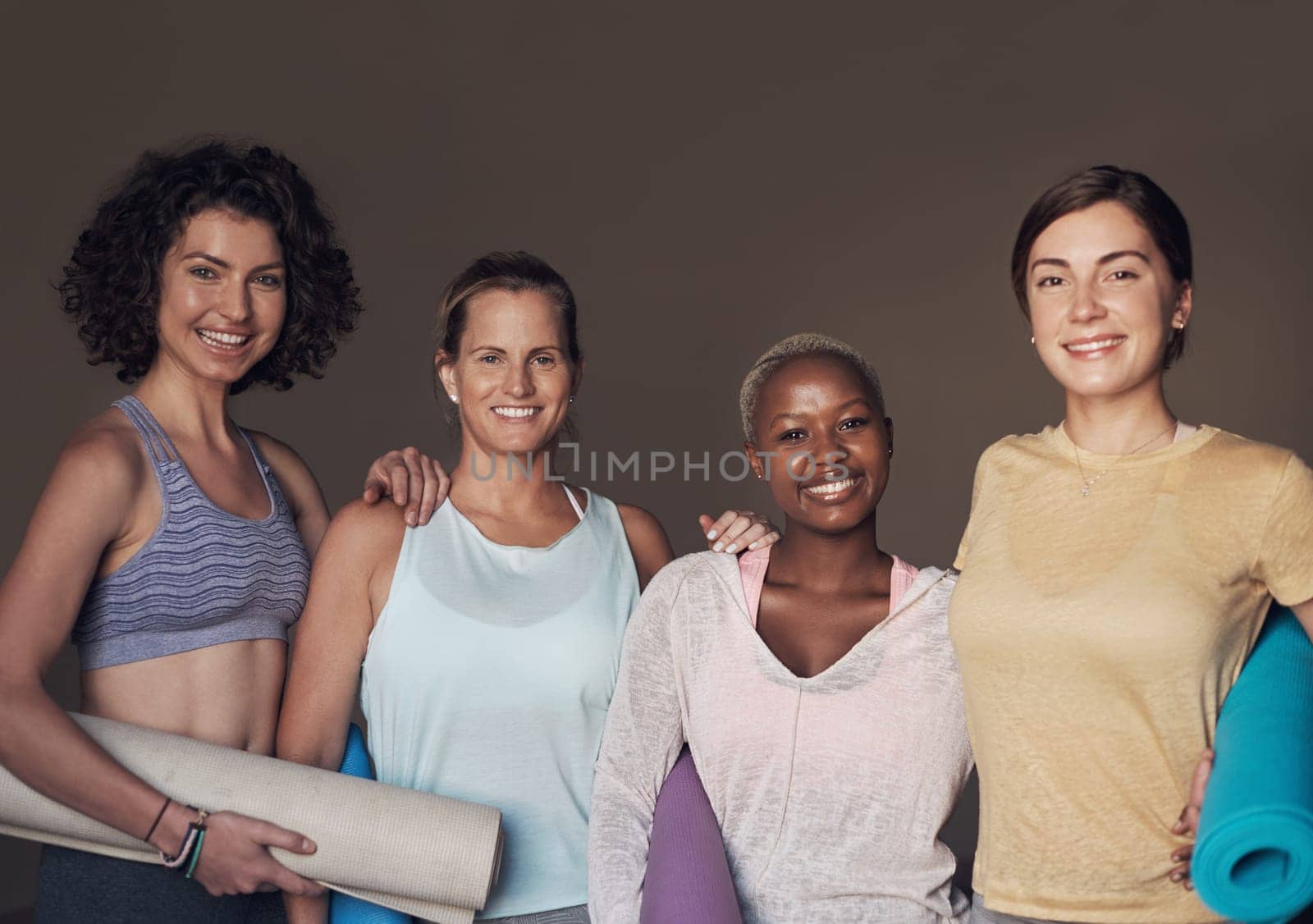 Yoga buddies for life. Cropped portrait of a young group of woman sitting together and bonding during an indoor yoga session. by YuriArcurs