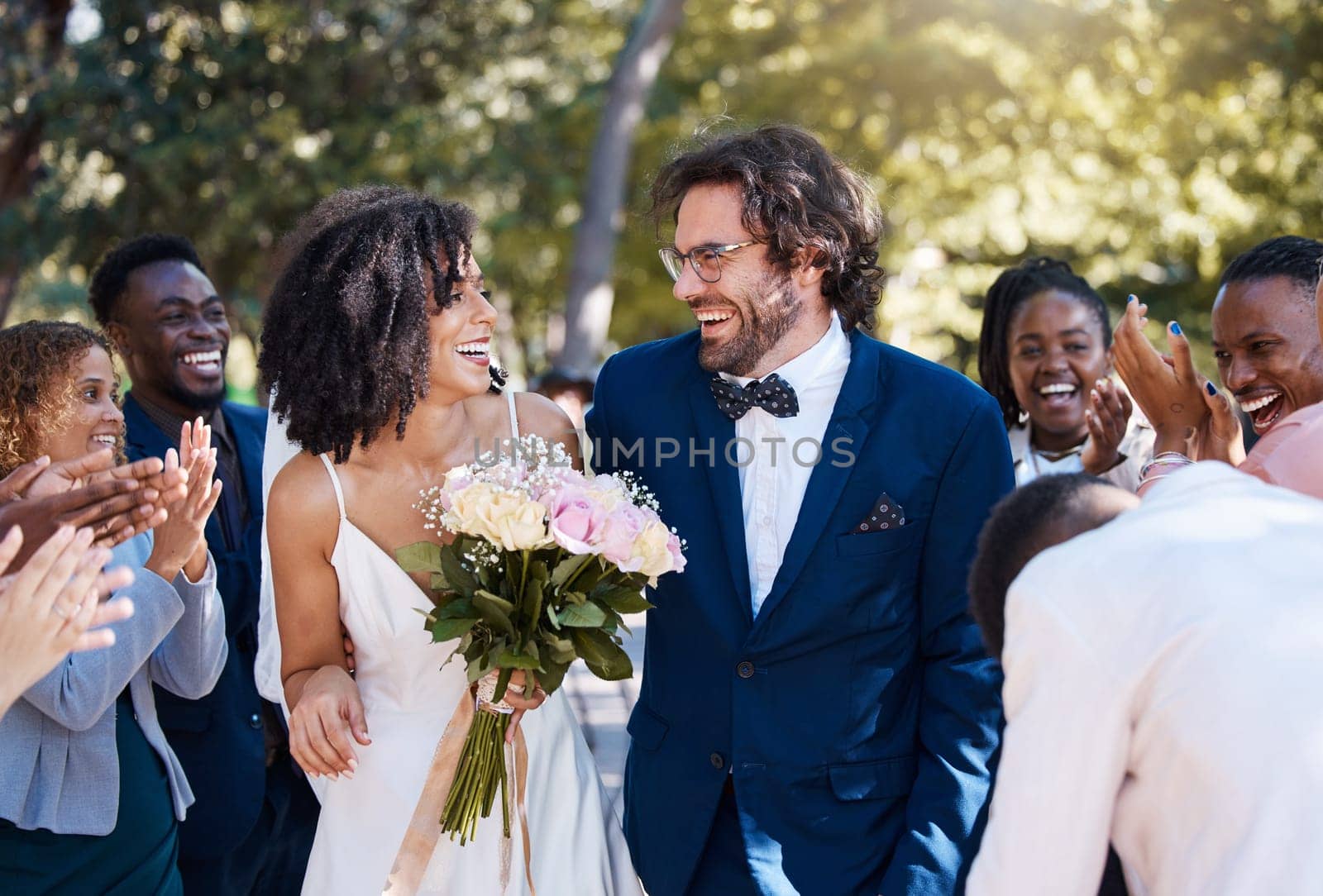 Celebration, applause and wedding bride and groom with happy, excited and cheerful guests. Interracial love and happiness of couple at marriage event together with clapping and joyful smile