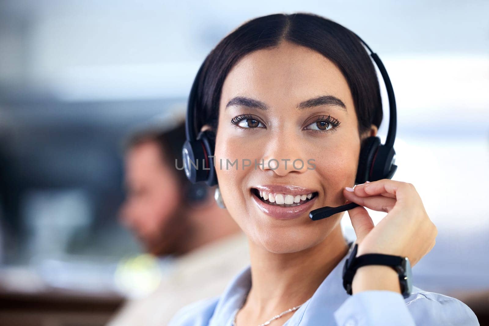 Customer service, woman with a headset and at her desk in a office at her workplace. Consultant or telemarketing, support or online communication and female call center agent smile at workstation.