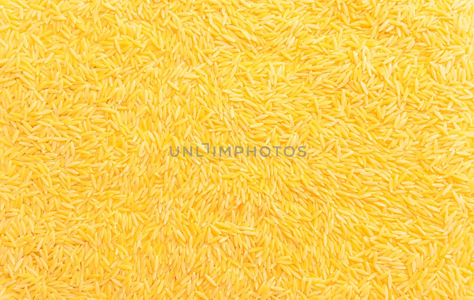 Background texture of dried risoni, orzo pasta. Italian cuisine. Durum wheat semolina pasta for risotto and salads. Orzo pasta of rice shape. Closeup, horizontal plane, top view, flat lay