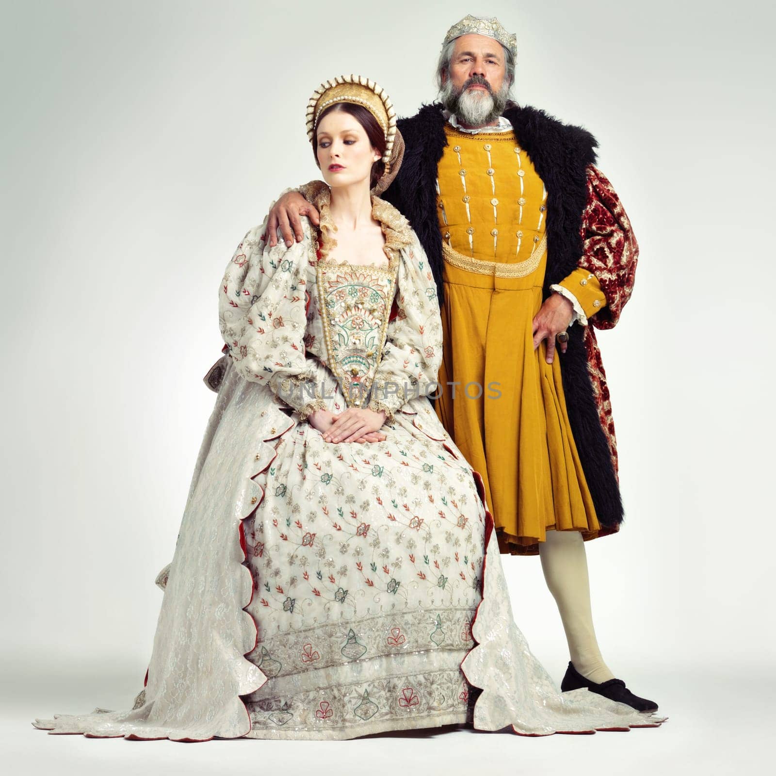 King, queen and crown with a couple in studio on a gray background during the renaissance or victorian period. Royalty, history and vintage with a man and woman monarch, leader or ruler of a kingdom.