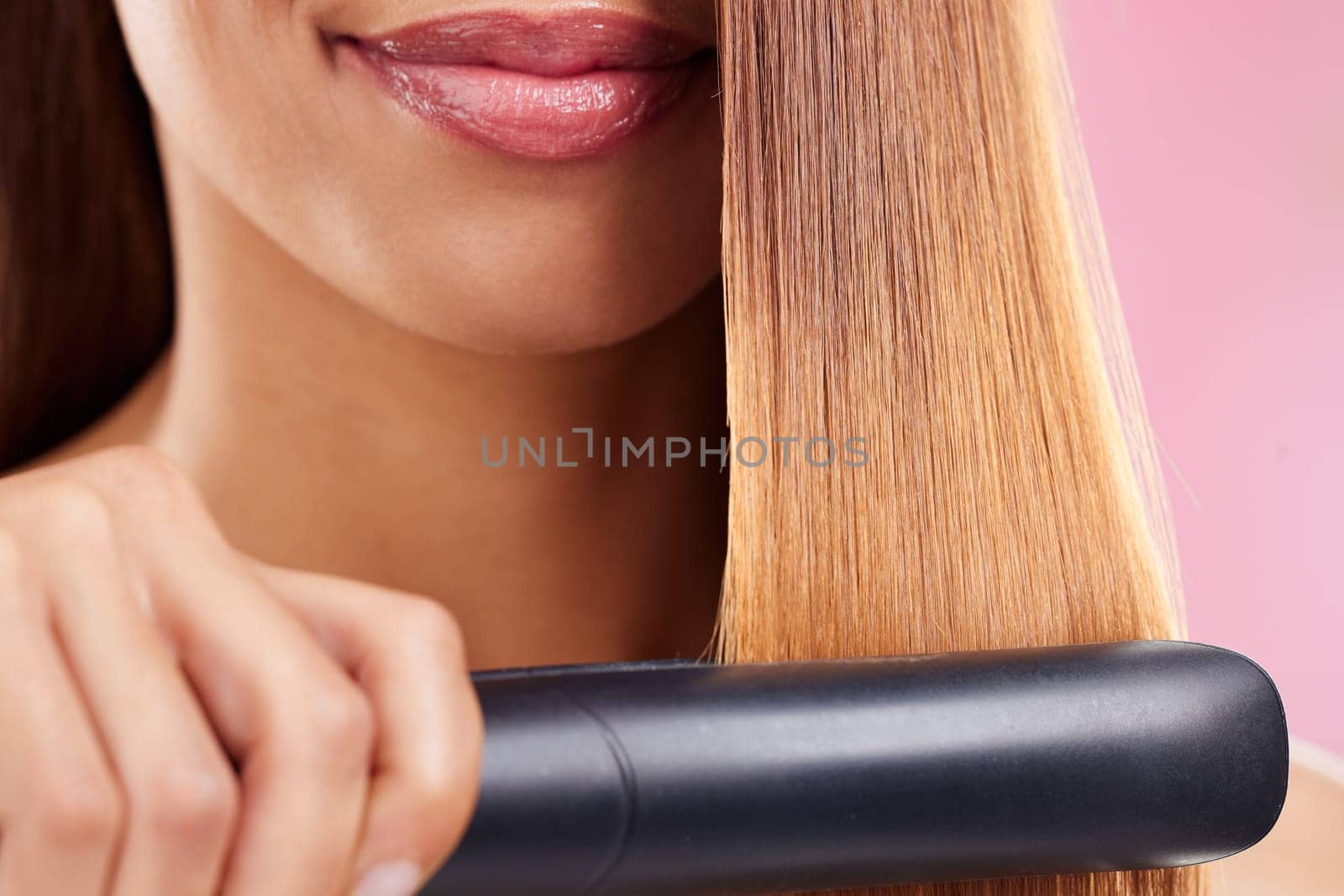 Closeup, woman and hair straightener for care, texture and beauty against a studio background. Zoom, female and girl with salon tool, treatment and grooming for confidence, aesthetic and cosmetics.