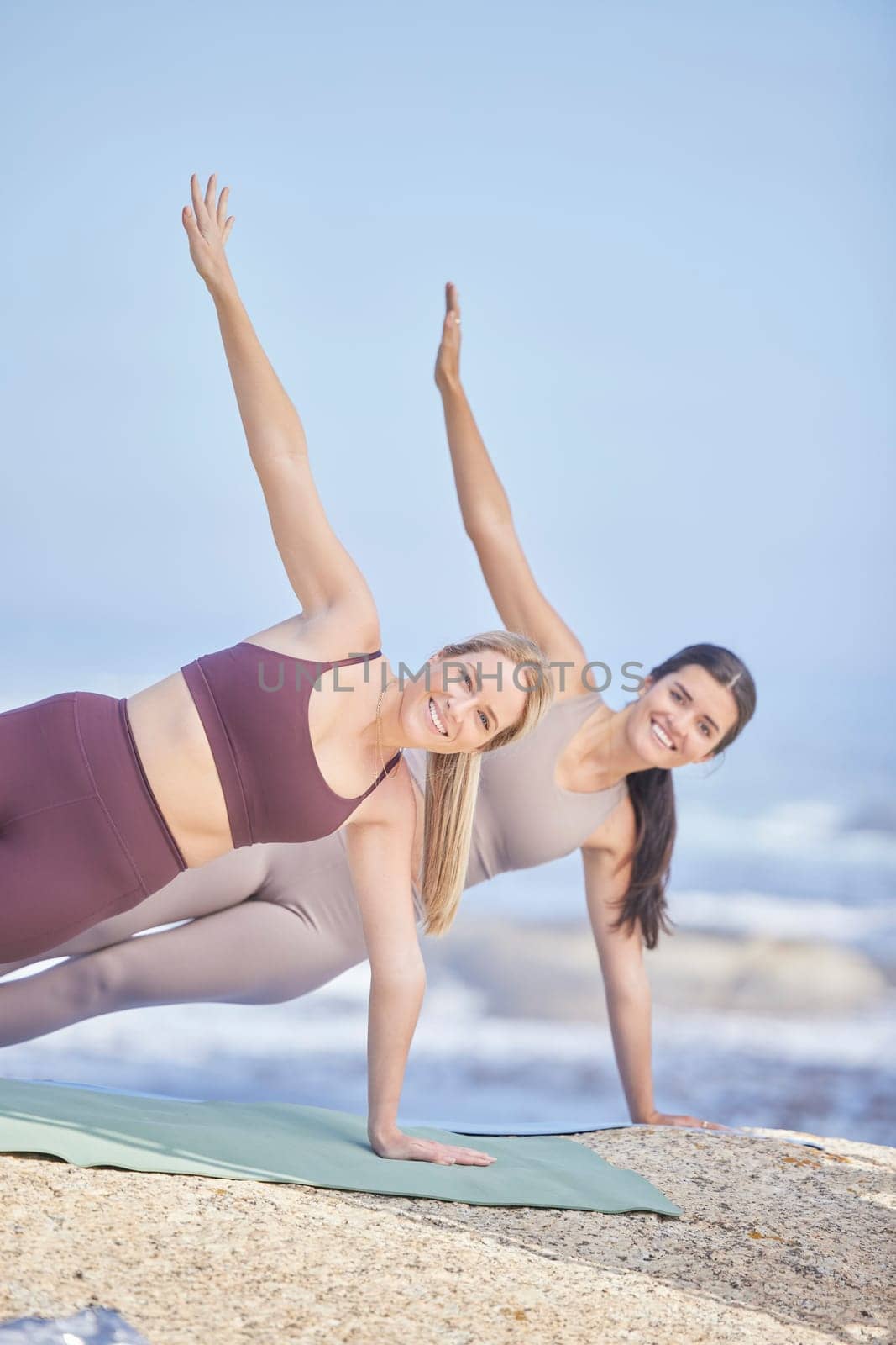 Stretching, outdoor and portrait of women exercise in nature for fitness, peace and wellness. Yoga friends at beach for training workout or energy for mental health, side plank and balance with smile.