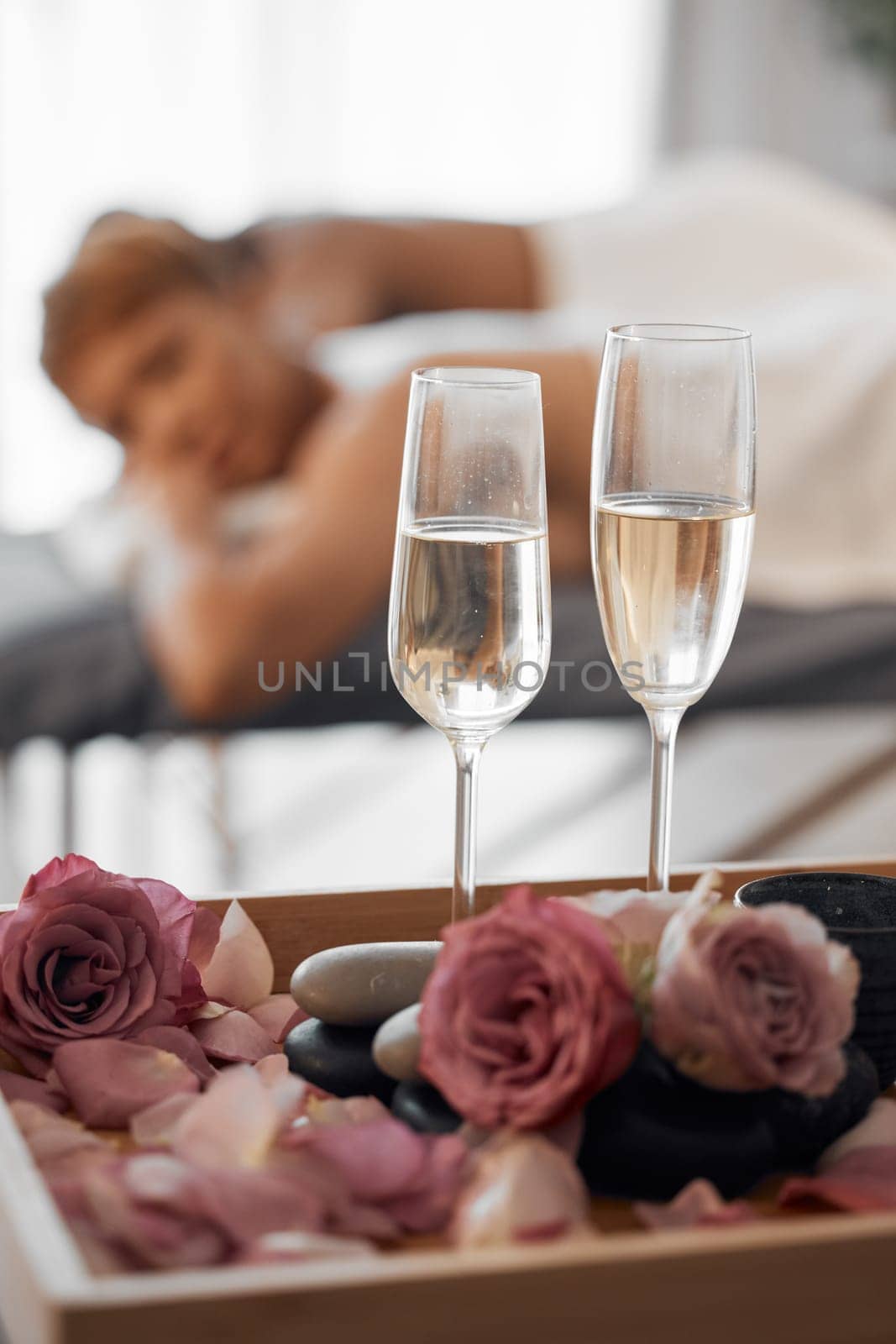 Champagne, massage and couple relax together for a anniversary, love and calm spa experience. Wellness, alcohol with flowers and luxury physical therapy activity of man and woman for romance and rest by YuriArcurs
