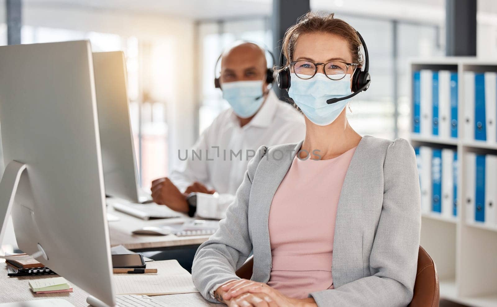 Covid, call center and portrait in office with medical mask for safety, health and protection from virus at pc. Consultant, telemarketing and workplace people with corona face mask at computer. by YuriArcurs
