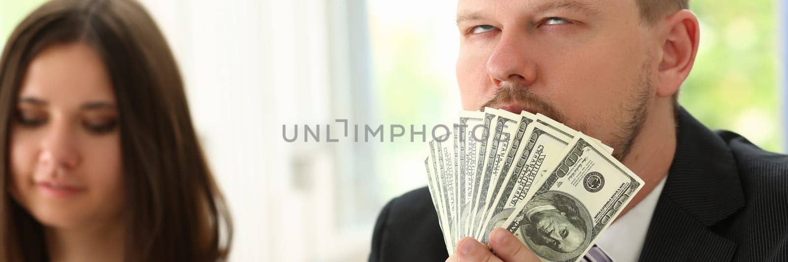 Man holds up dollars banknotes and enjoys success of financial income and growth by kuprevich