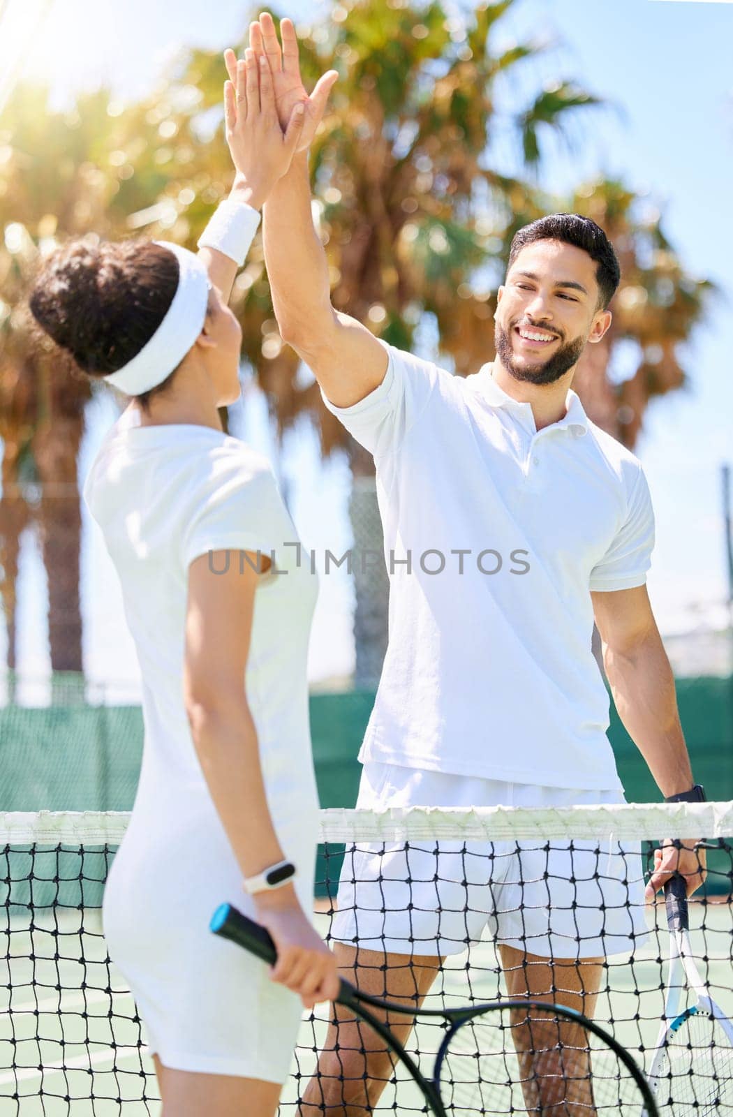 Tennis, friends and high five for sports game, exercise or workout together on the tennis court. Man and woman tennis player touch hands with smile in sport fitness for fun friendly match outdoors.