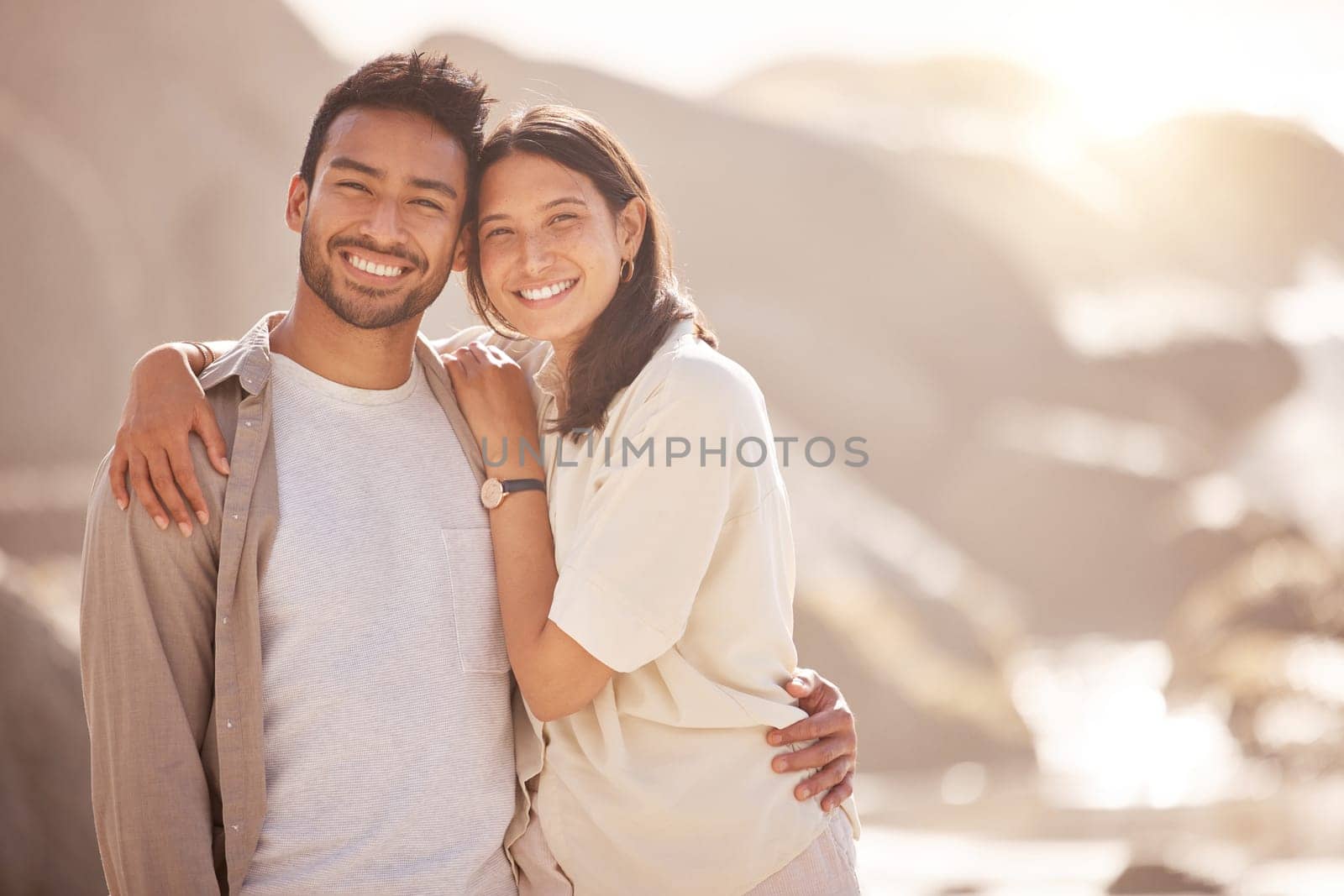 Portrait, couple and holiday with hug at ocean with happiness in the summer on the weekend. Face, smile and man with woman at the beach for travel with the sunshine for bond together on a trip. by YuriArcurs