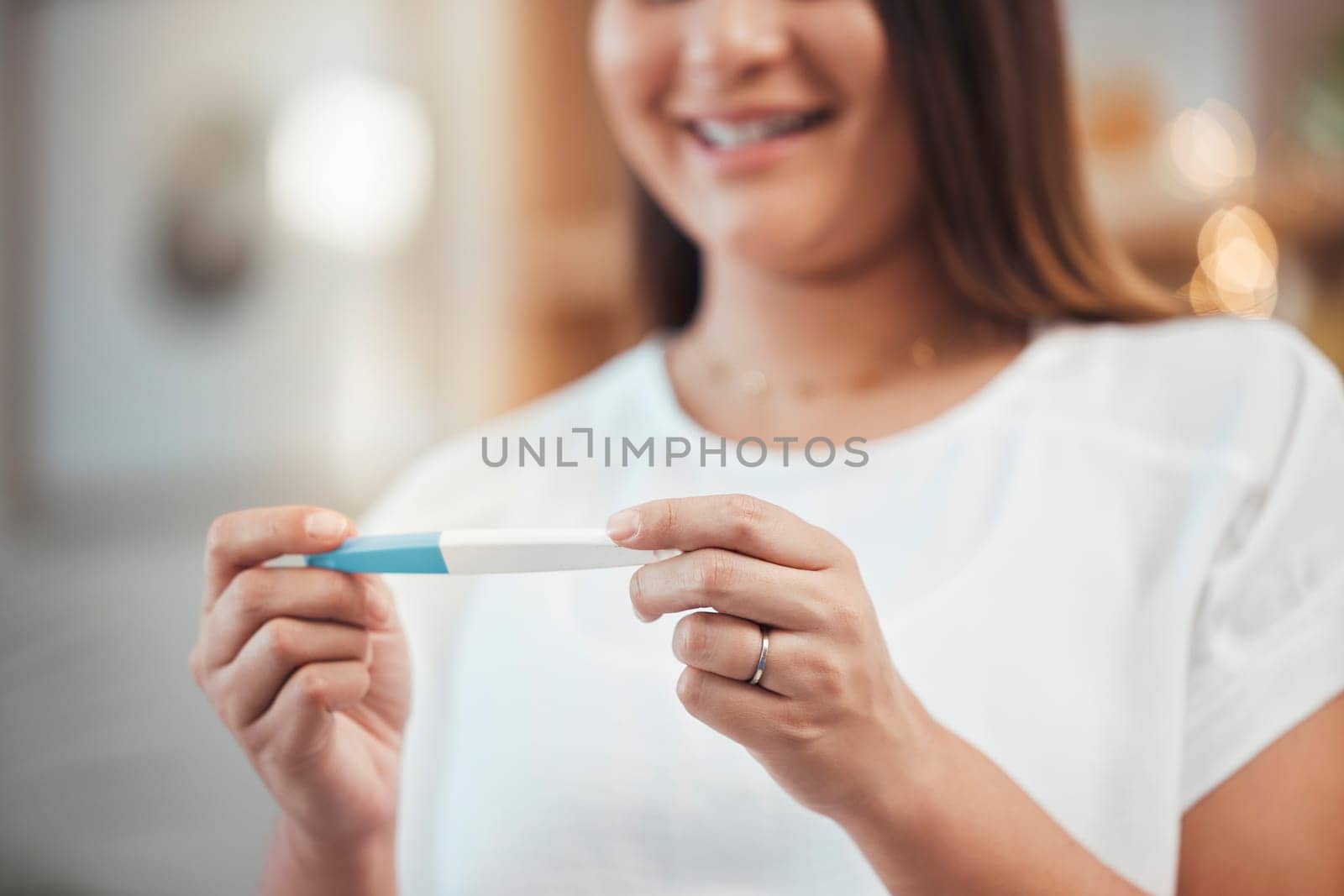 Woman, hand and pregnancy test result with a happy mother to be ready for her baby at home. Mom, pregnant stick test and excited female ready for children or babies feeling happiness about family by YuriArcurs