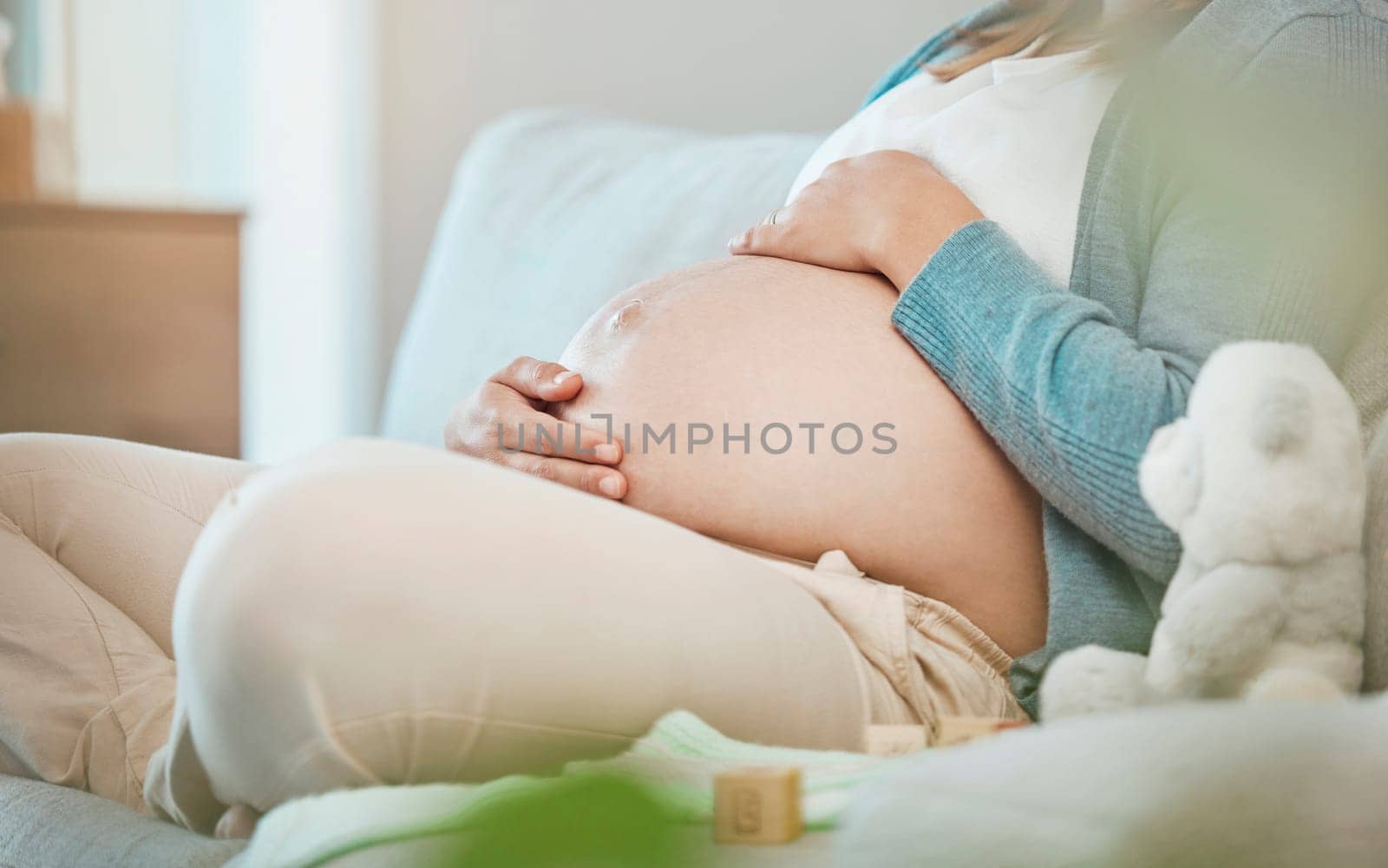 Pregnant, stomach and mother bond with her baby while resting during maternity at home. Tummy, belly and pregnancy with a mommy to be holding her abdomen and caring for her kid while relaxing by YuriArcurs