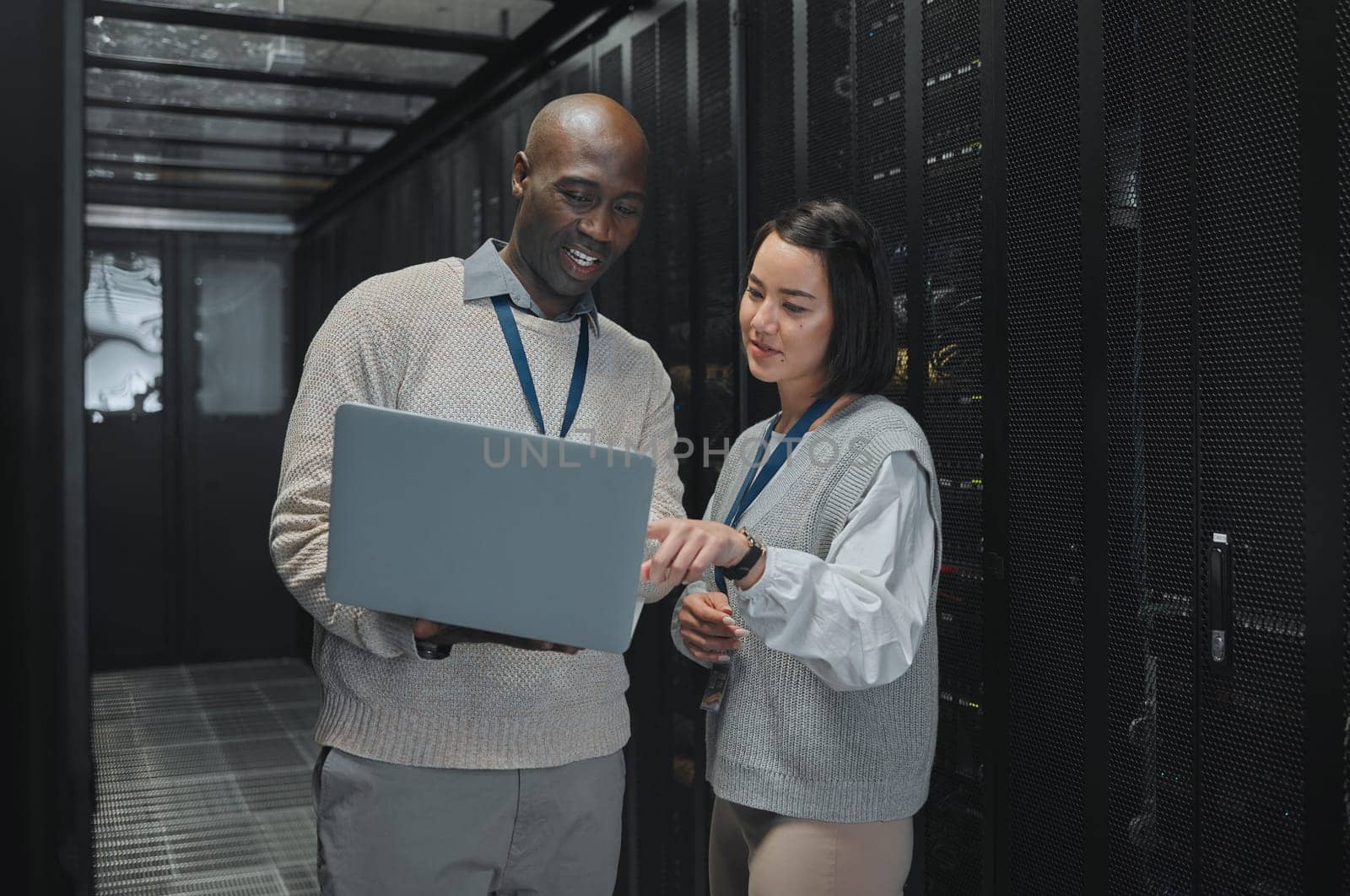 Business, black man and woman with laptop, servers and cyber security for connection, data analytics and conversation. IT specialist, female programmer and employees with device and cloud computing by YuriArcurs