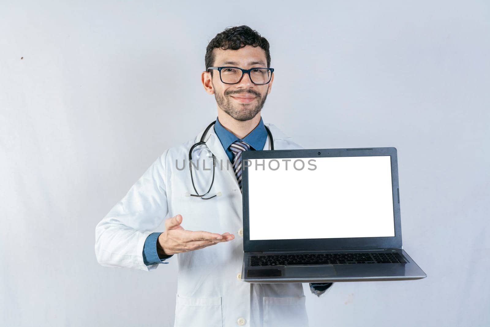 Smiling doctor showing laptop screen isolated. Handsome doctor pointing at laptop screen isolated