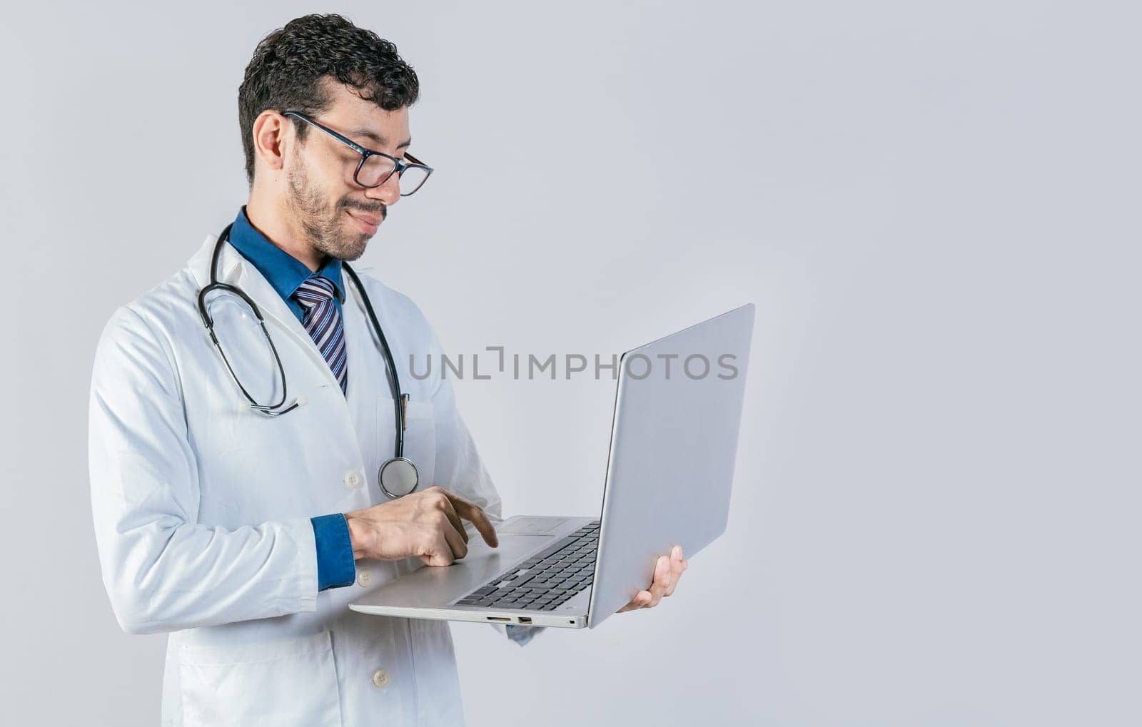 Handsome doctor using laptop isolated. Young doctor in glasses using notebook on isolated background, Smiling doctor standing using laptop isolated