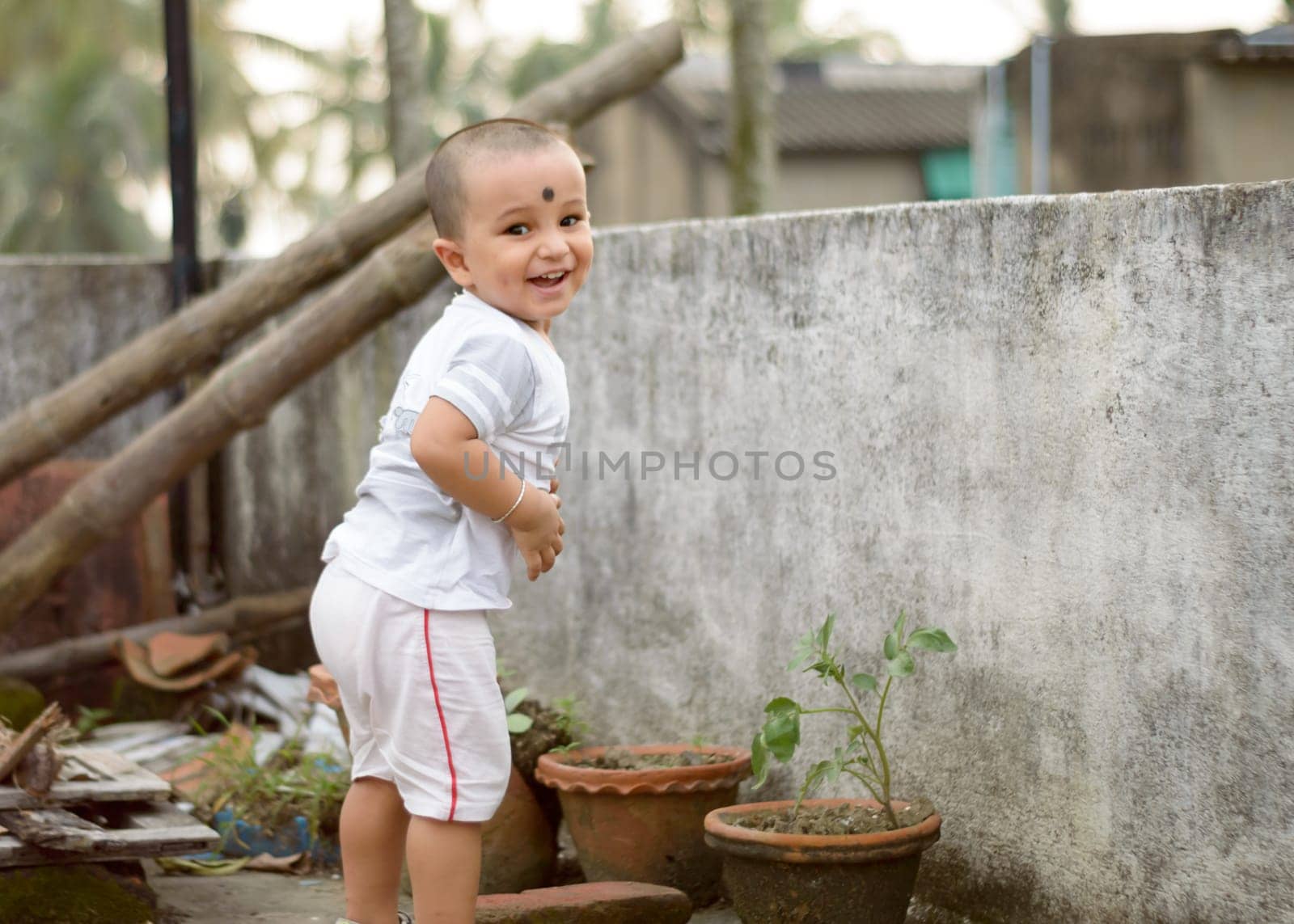 Cute smart naughty baby making a funny and looking at camera. Happy baby background.