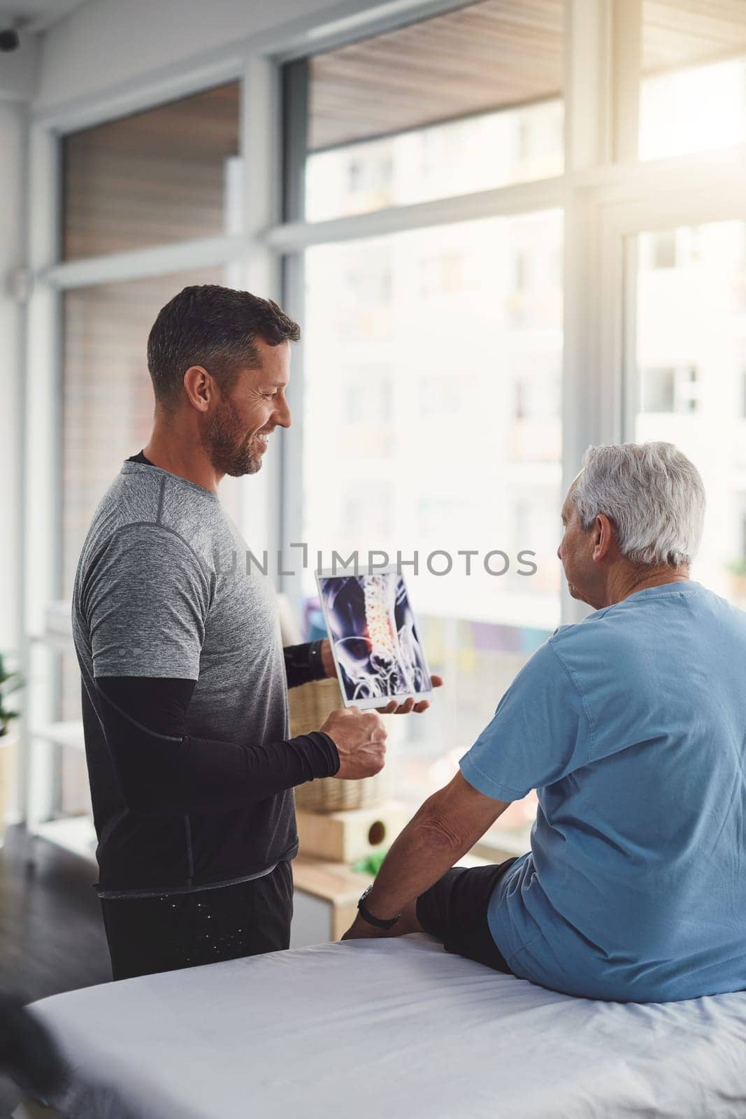 Your body has been recovering quite well. a young male physiotherapist assisting a senior patient in recovery. by YuriArcurs