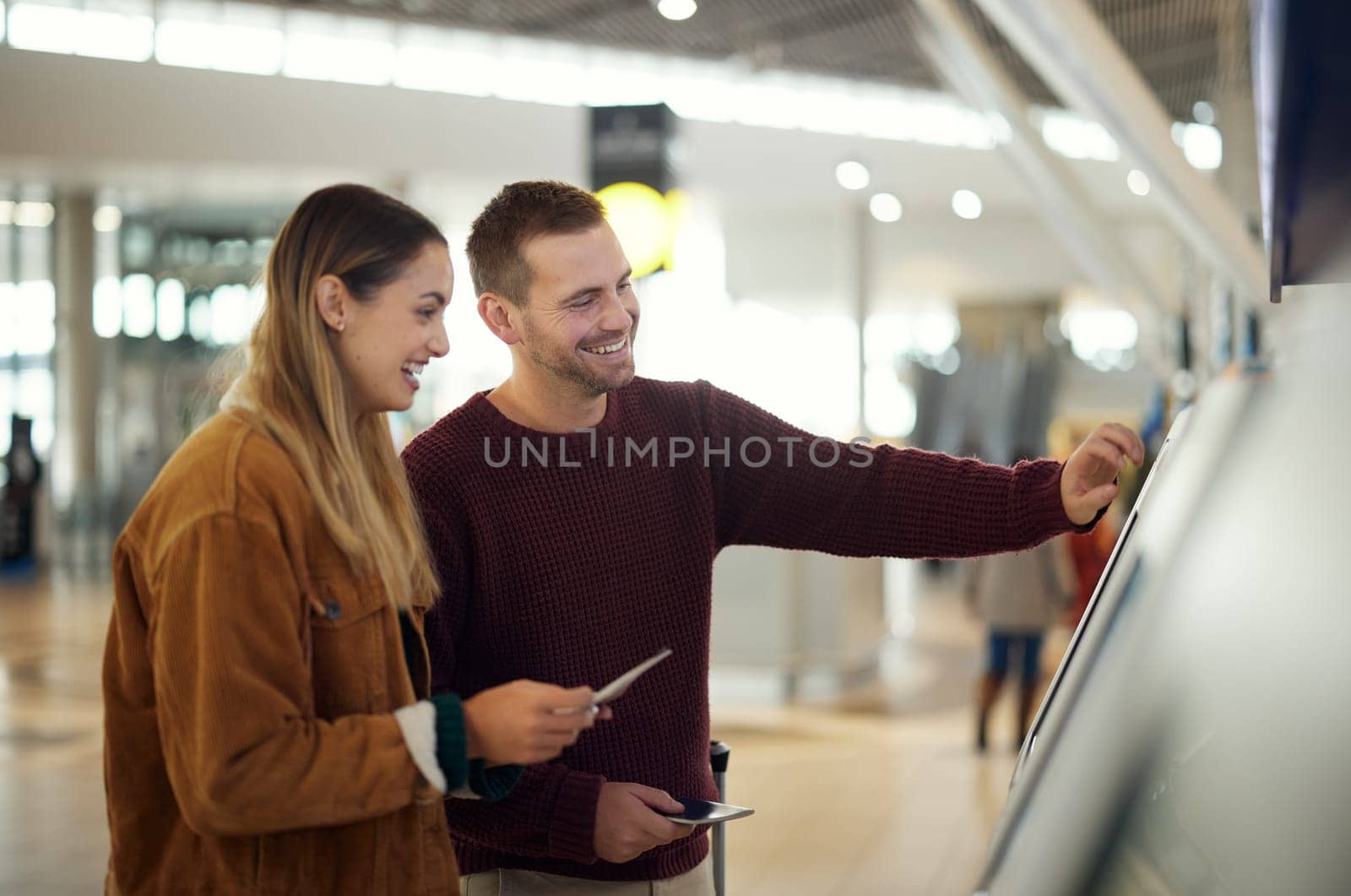 Couple in airport typing on self service screen for digital passport identity or flight data to travel on airplane. Smart check, woman or happy man pressing code for on futuristic technology at kiosk.