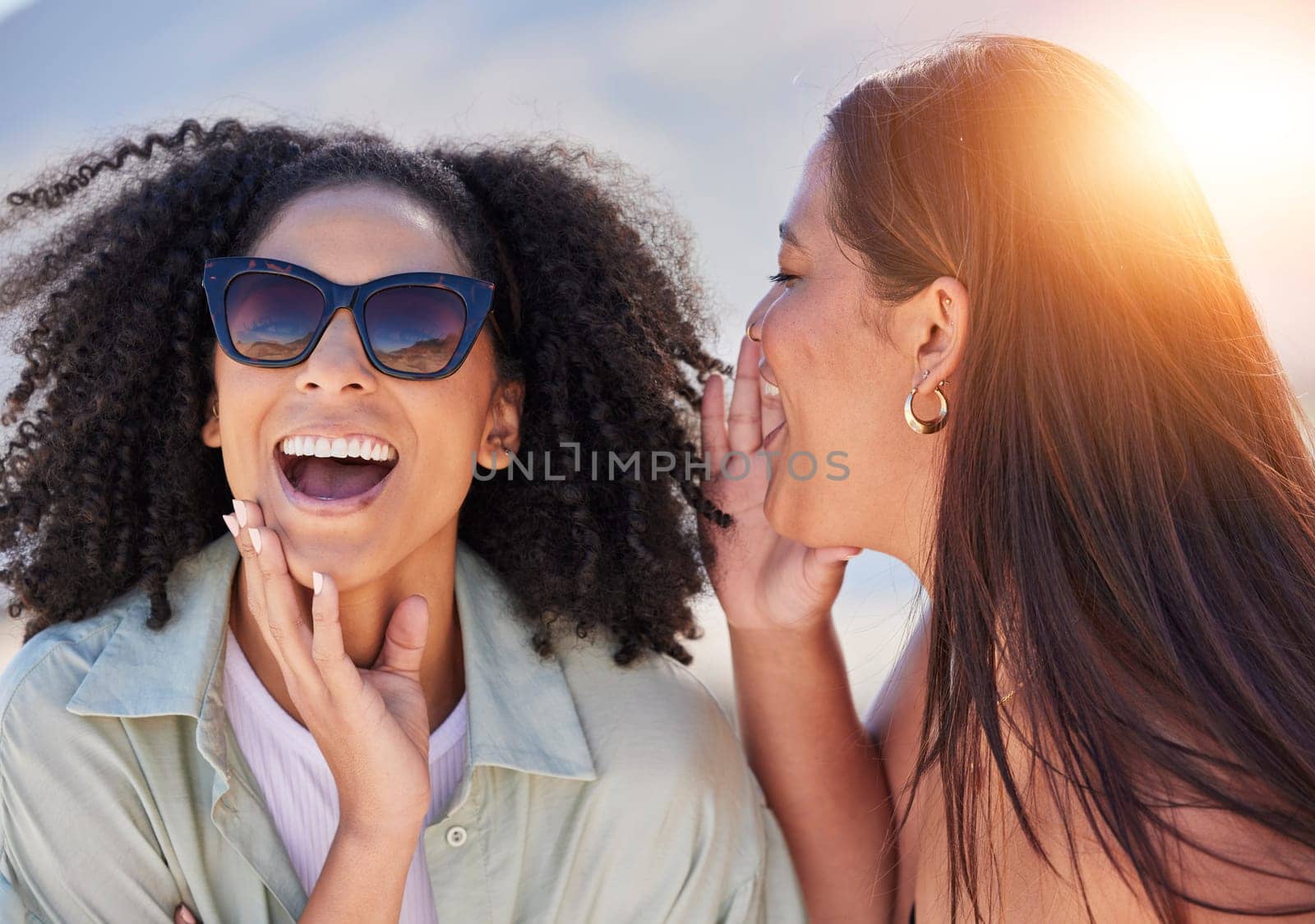Girl friends, whisper and happy communication of a woman with a secret laughing outdoor. Lens flare, friend conversation and summer holiday travel of people talking about a gossip story on vacation by YuriArcurs