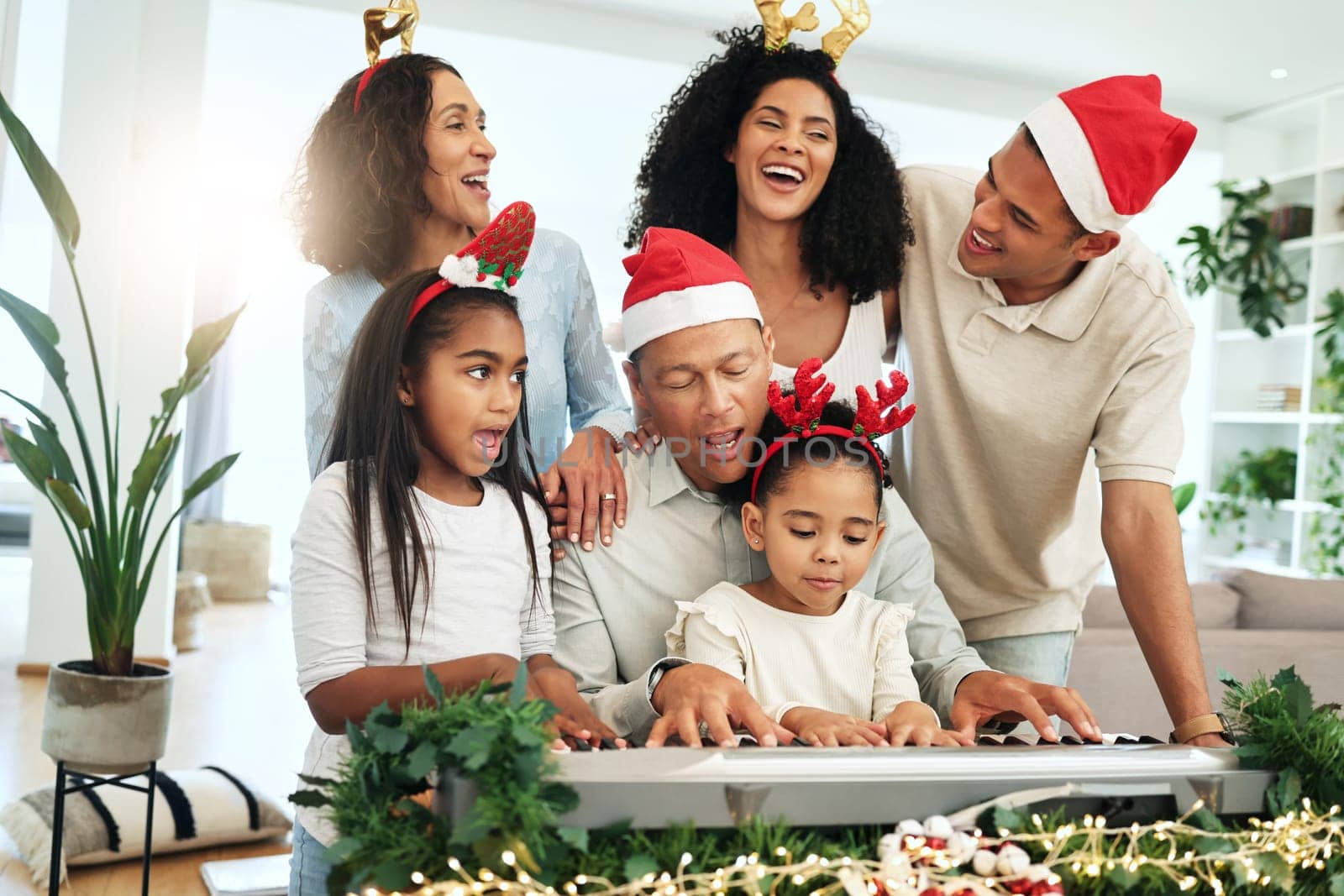 Love, Christmas and family singing, quality time and happiness with bonding, loving and smile. Grandparents, happy mother and father with children, Xmas and festive season with decorations and carols.