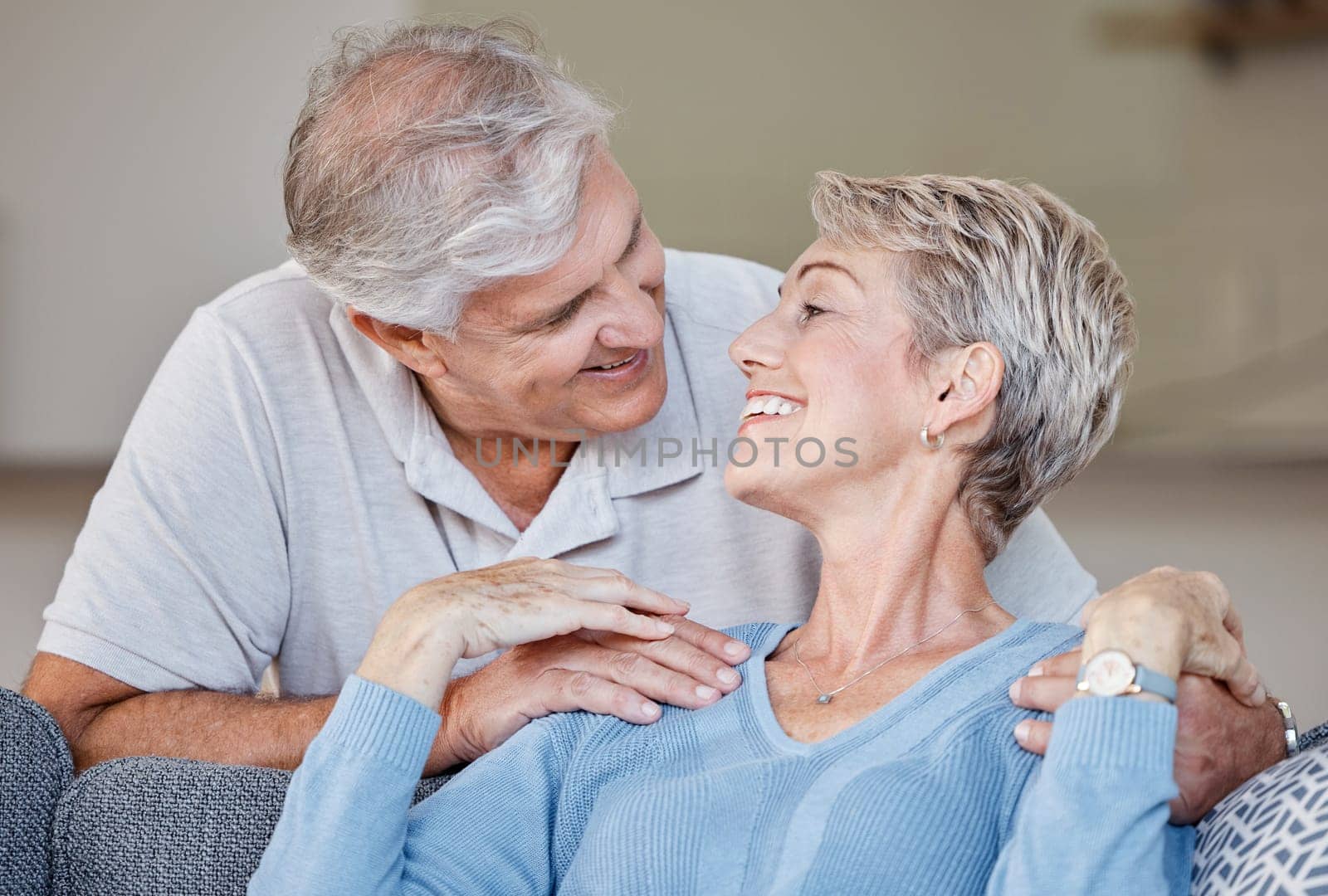 Love, senior couple and relax on a sofa, smile and happy while sharing intimate moment, bond and romance in living room. Happy family, retirement and senior embrace on a couch, in love and relaxing.