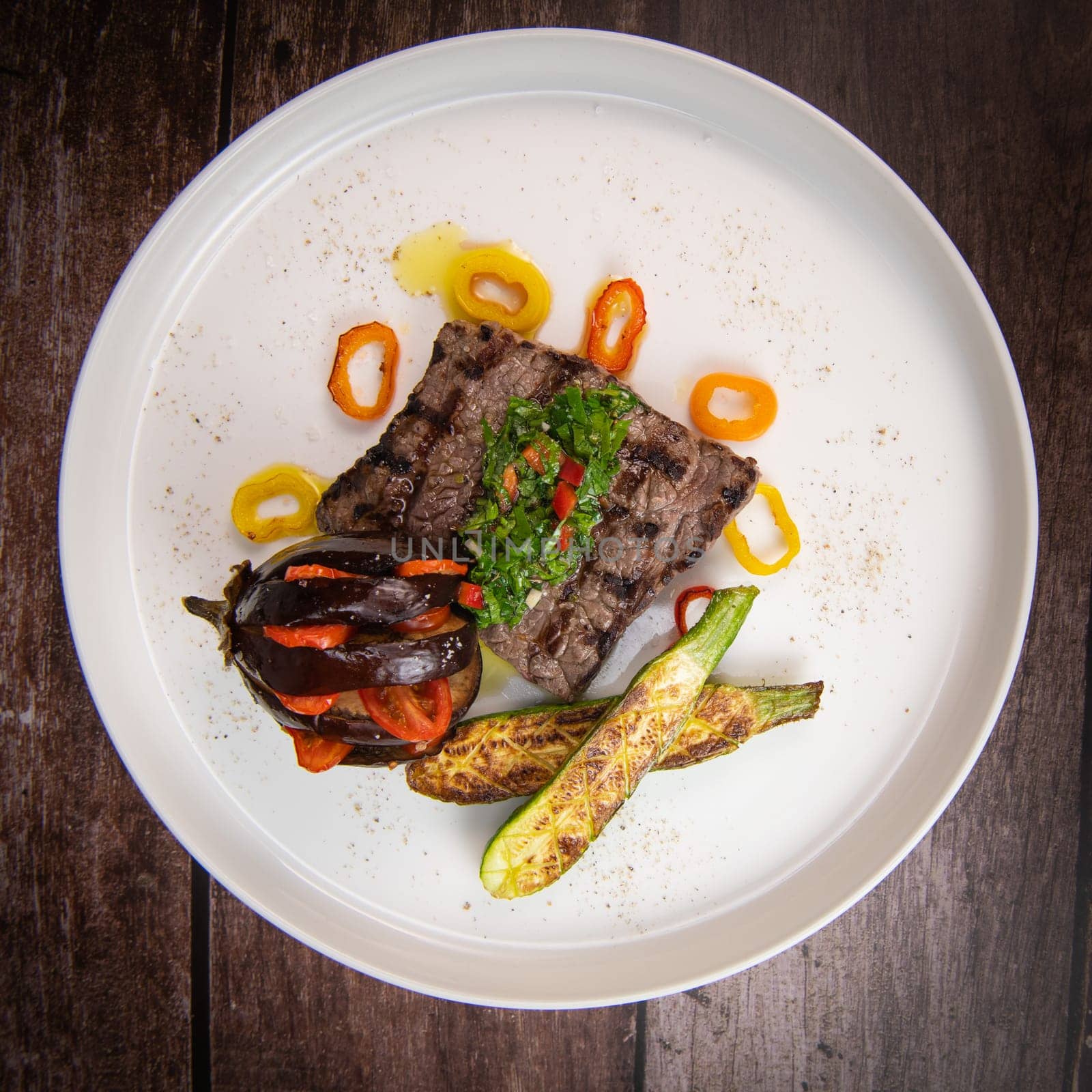 Recipe for grilled steak with chimichurri sauce, accompanied by a farandole of vegetables. High quality photo