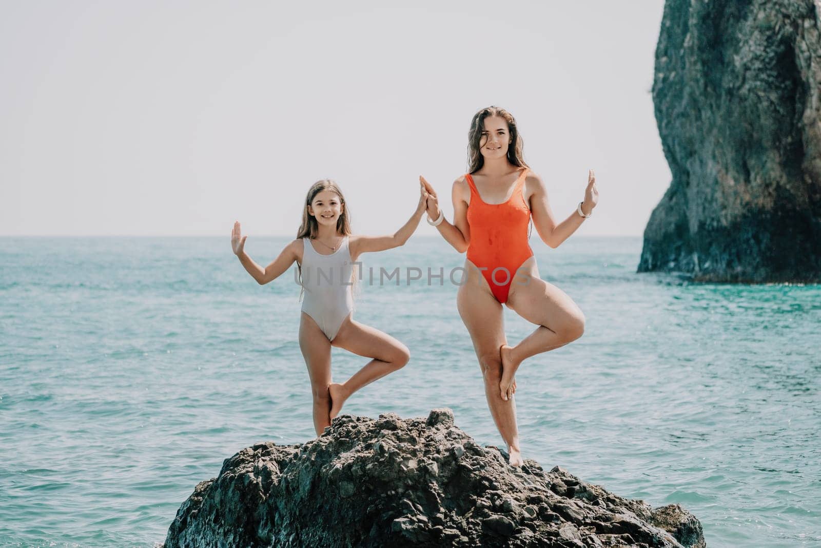 Silhouette mother and daughter doing yoga at beach. Woman on yoga mat in beach meditation, mental health training or mind wellness by ocean, sea