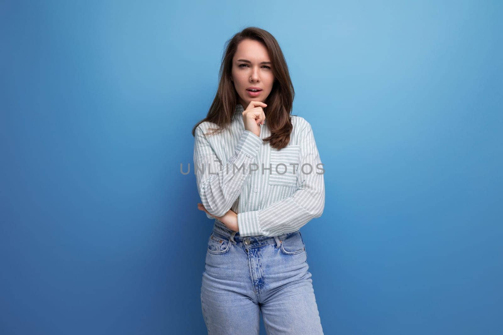 pretty young brunette woman in shirt on studio background.