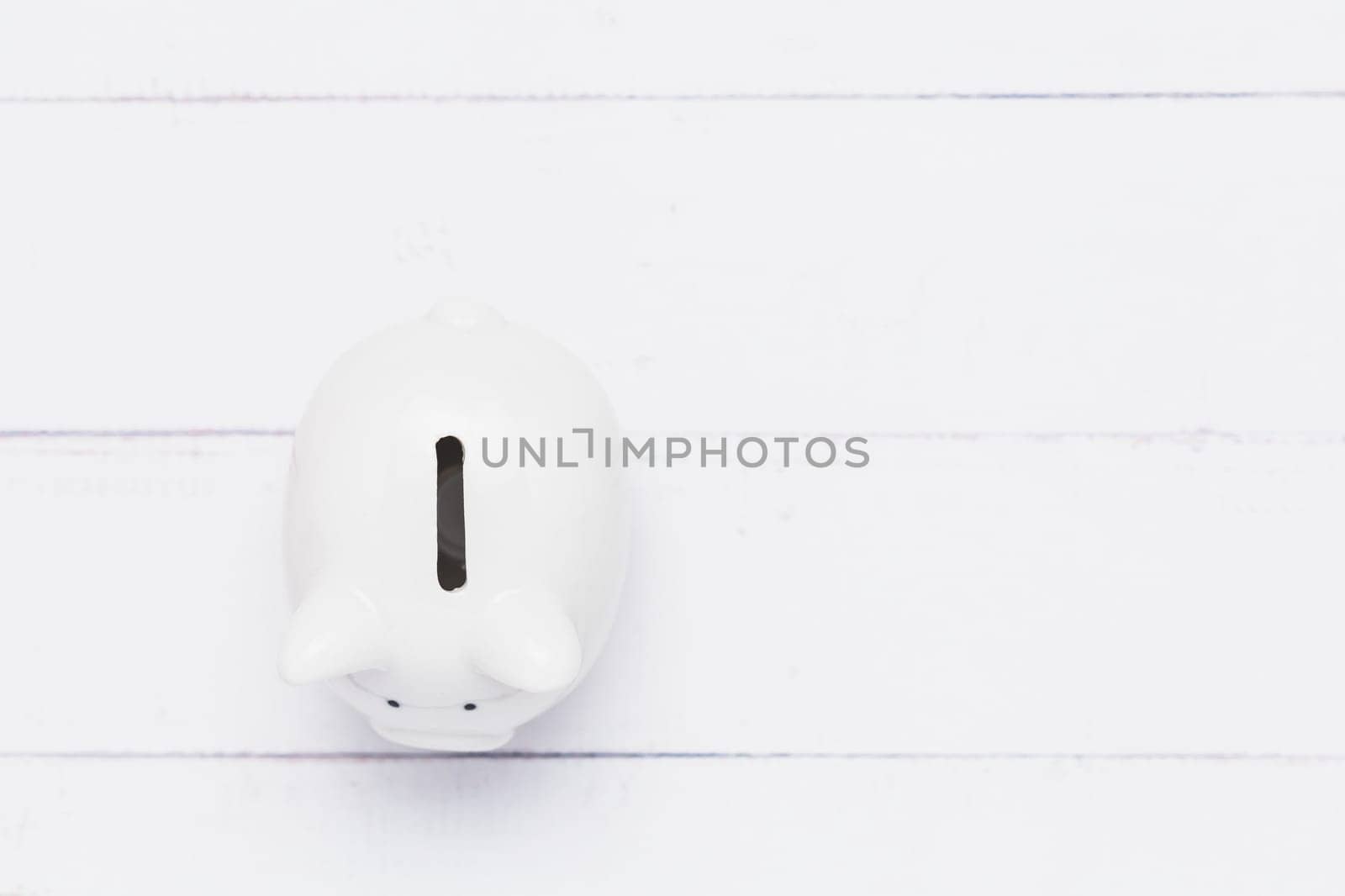 Top view of saving piggy bank on white table background for investment, business, finance and saving money concept