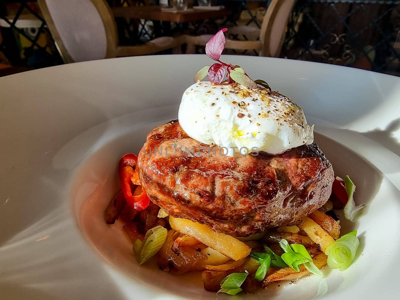 chopped beef cutlet on a pillow of potatoes with lettuce, poached egg and spicy gravy