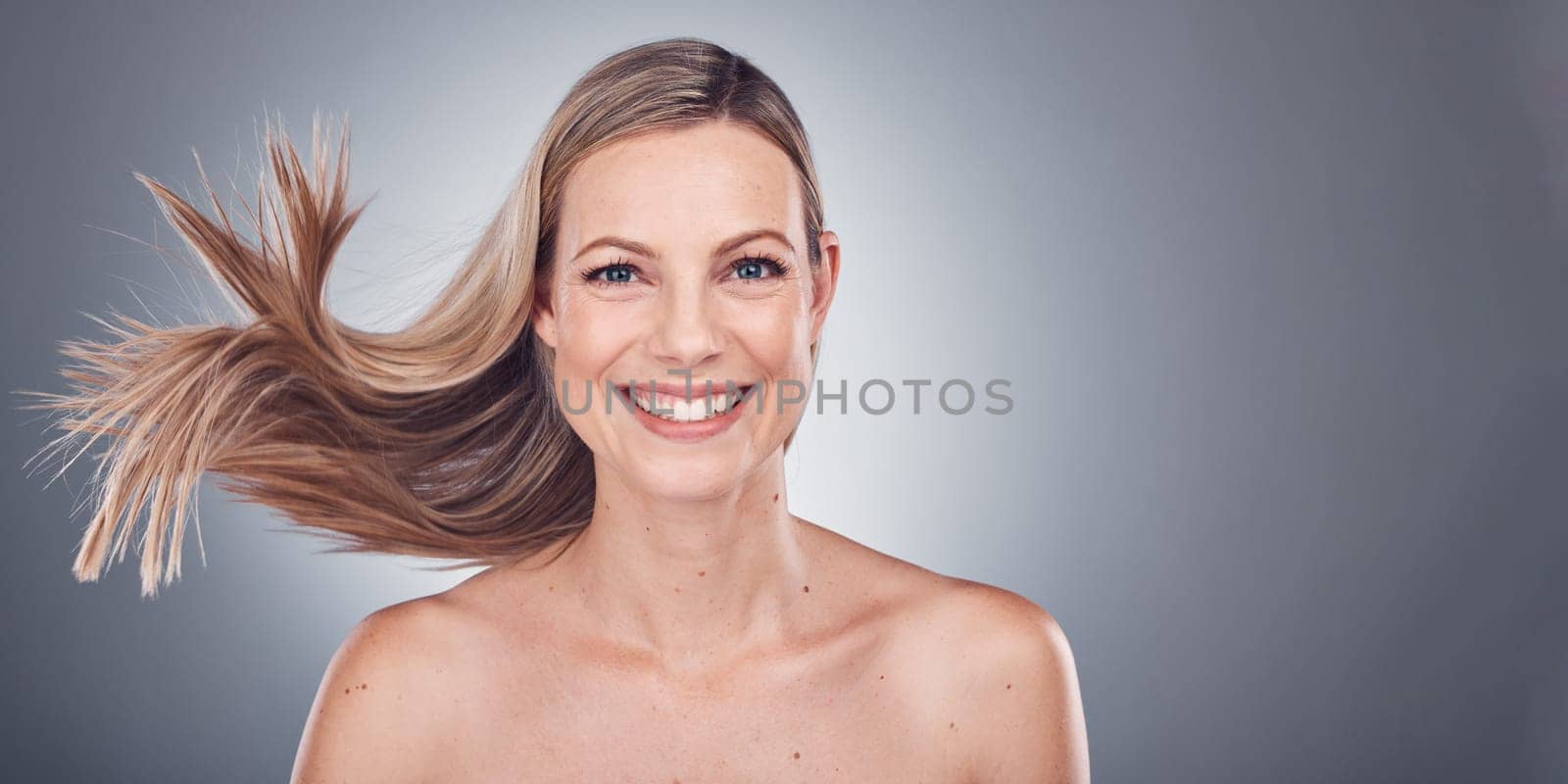 Woman in portrait, happiness and face with hair in air, beauty and keratin treatment, cosmetic care isolated on studio background. Mockup space, glow and hairstyle, natural cosmetics and skincare by YuriArcurs