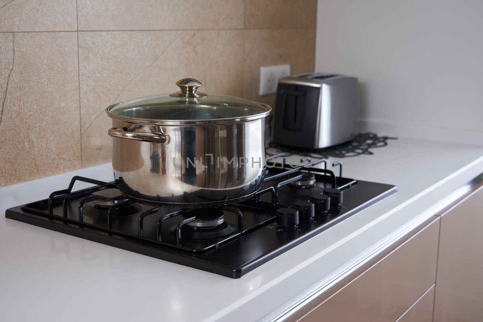 pan is on the stove in kitchen interior, Stainless steel pot. Cooking utensils concept