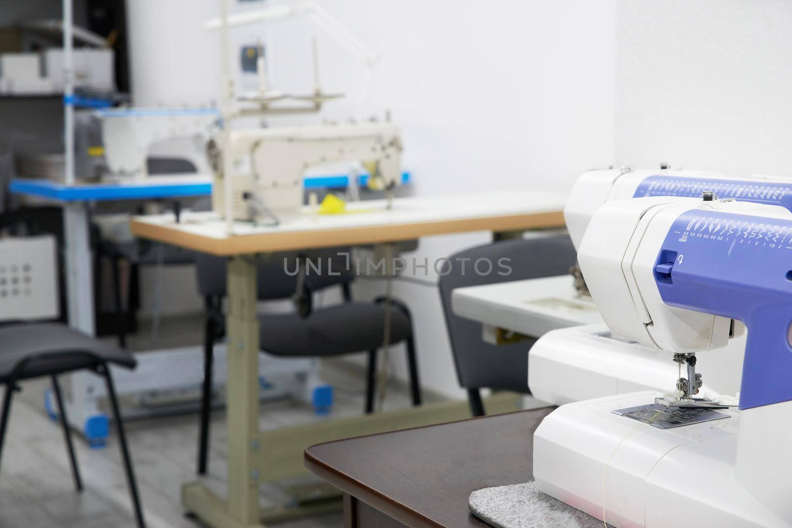 Row of sewing machines in empty atelier studio or tailor shop
