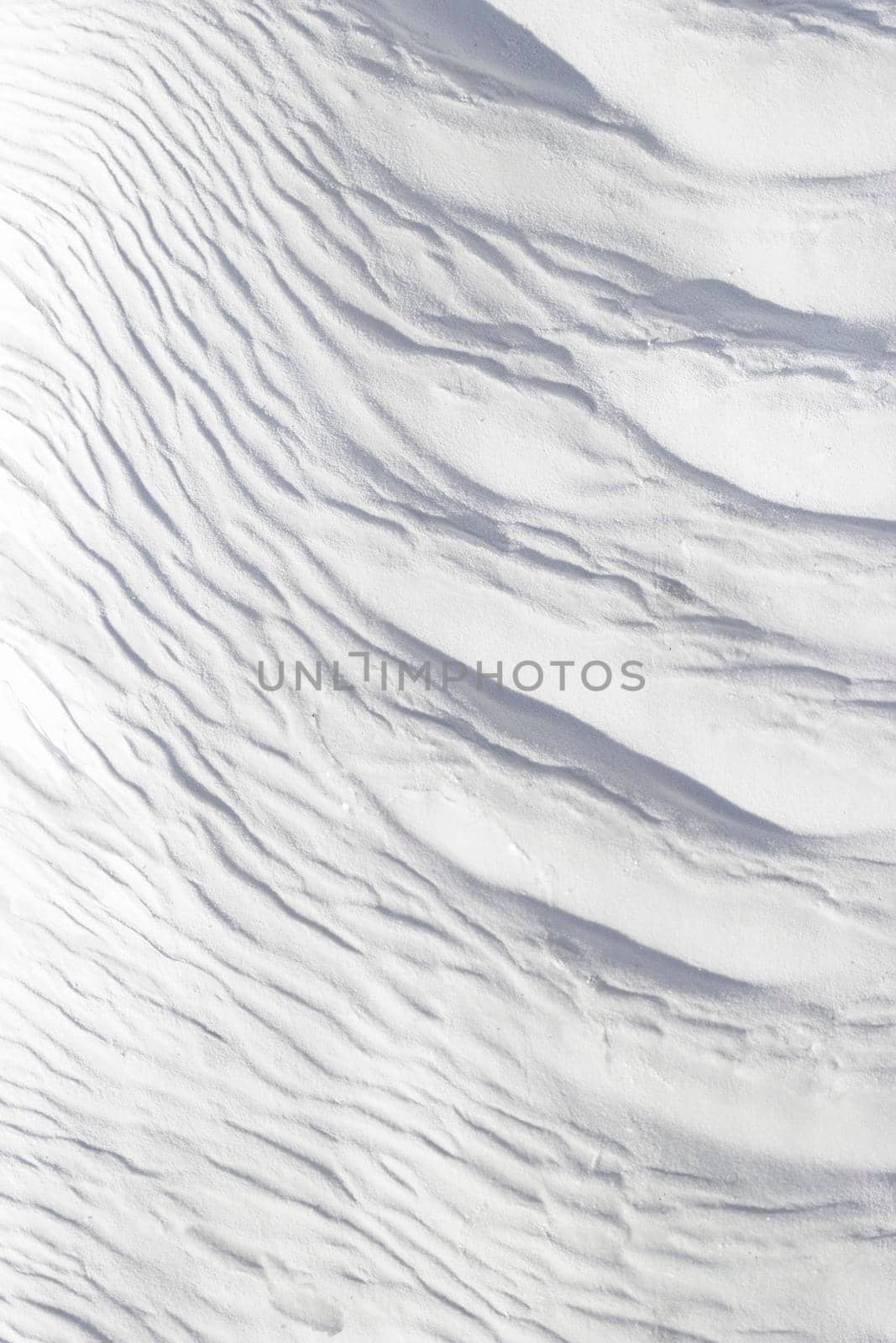 Textured effect of waves on surface of gray and white stone. Pamukkale travertine surface in Turkey.