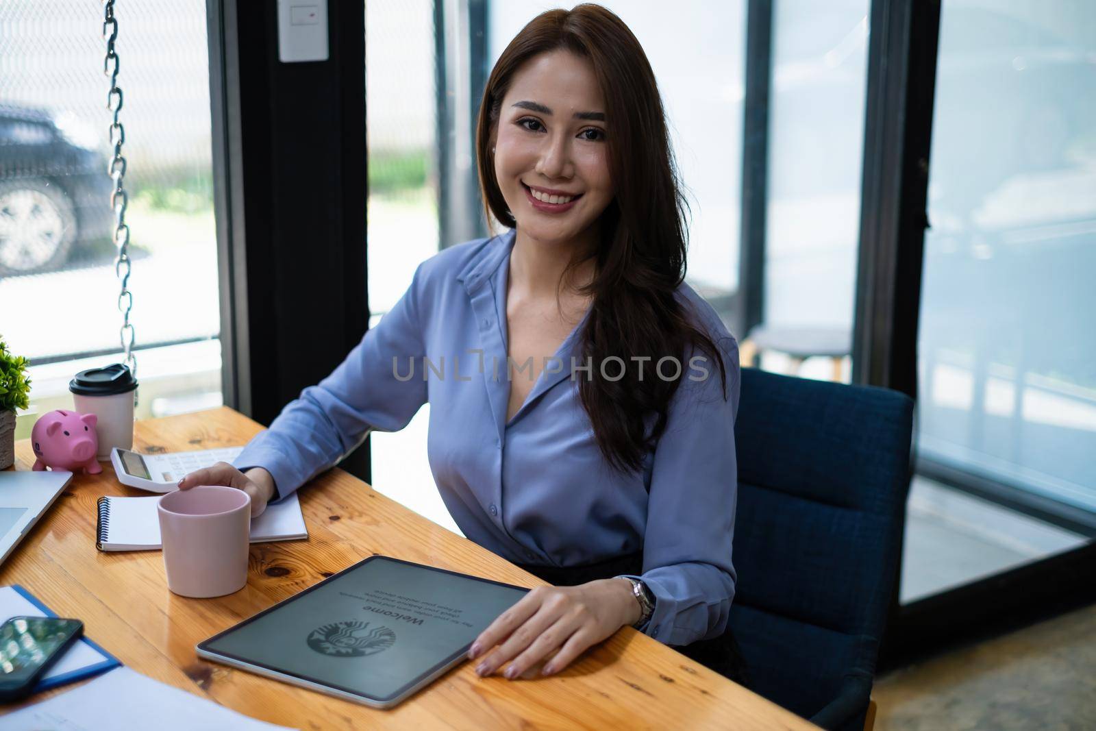 Chiang Mai, Thailand - August 23, 2021 : Woman sitting at Starbucks coffee shop and Starbucks logo in tablet.