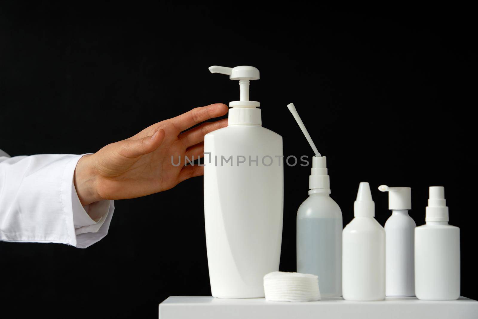Bottles of hand sanitizers and liquid soap on a black background