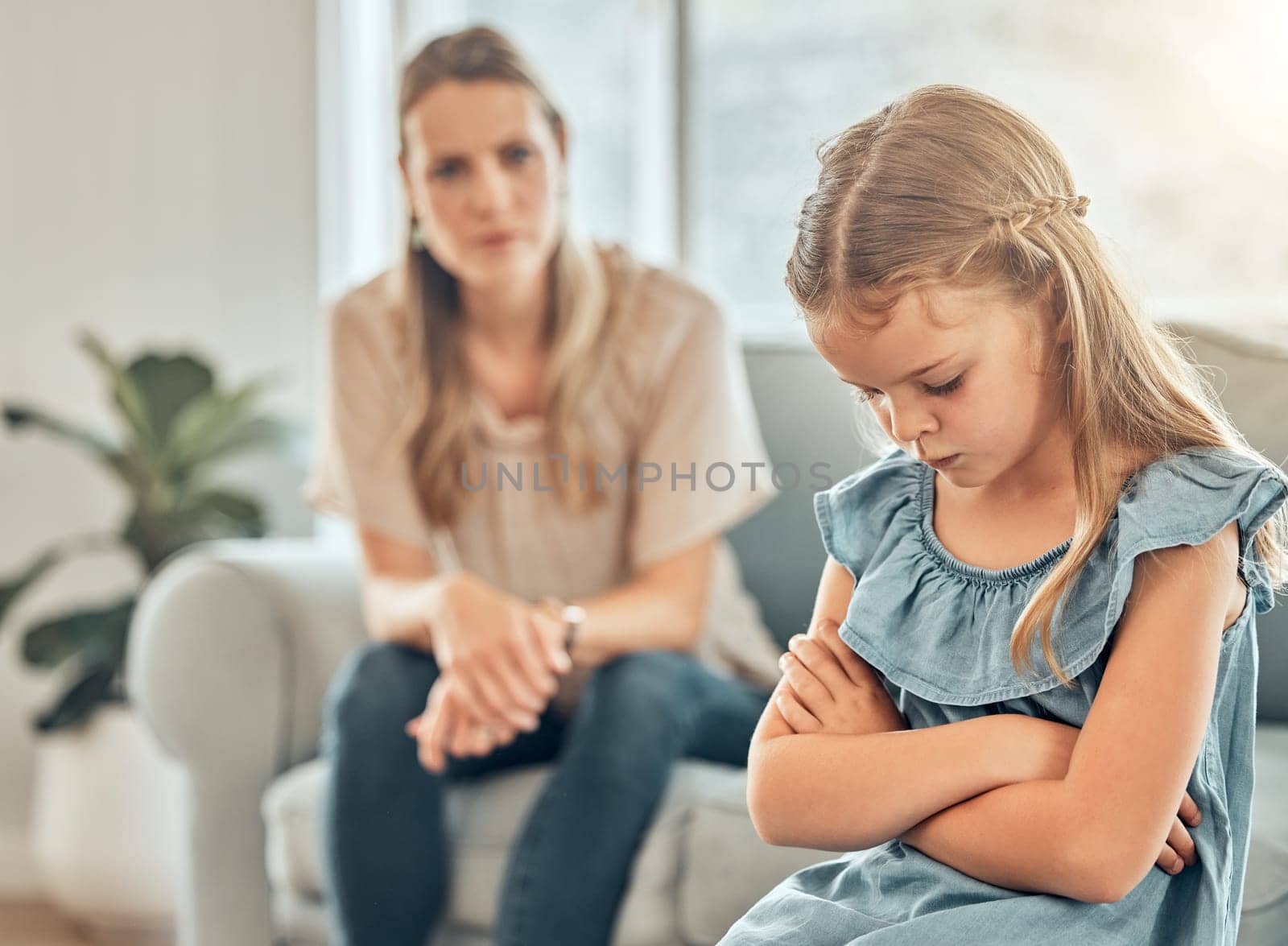 Angry mom, sad child and discipline in living room, frustration and problem with naughty girl behaviour in home. Scolding, punishment and frustrated mother, stubborn kid and communication with anger