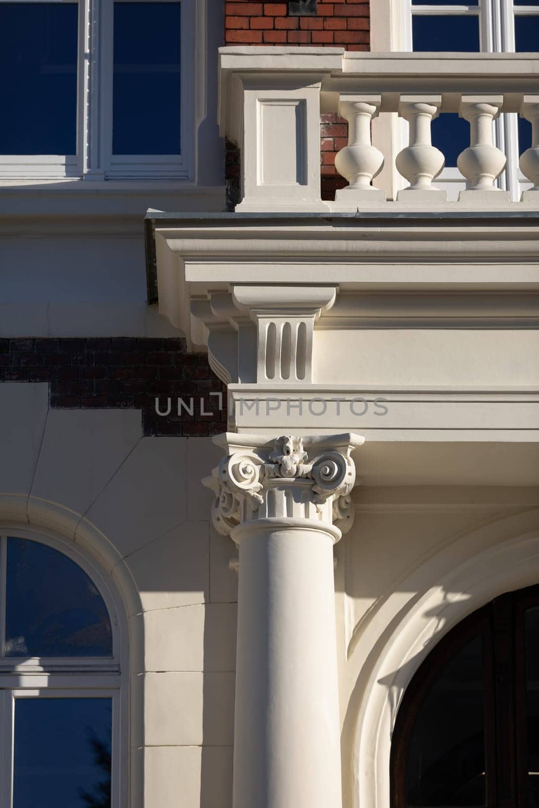 A vertical frame showing a section of a column supporting a balcony with ornaments maintained in the Neo-Gothic style.