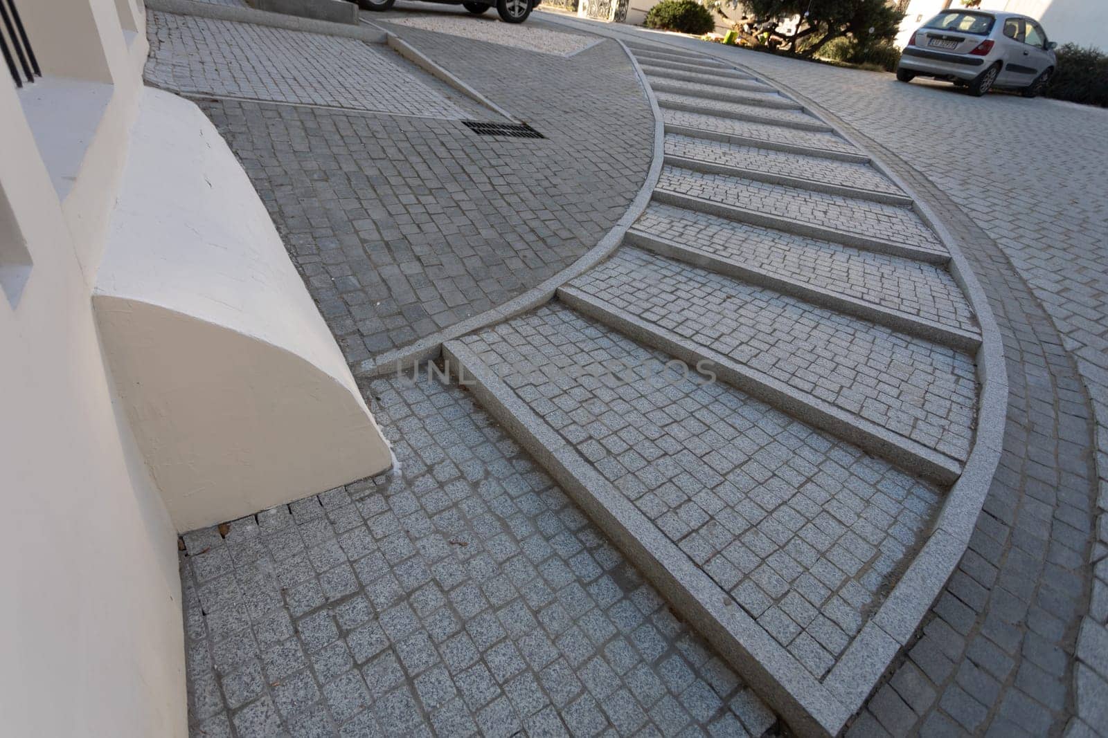 Paving thistle laid evenly in a curve into a spacious staircase leveling the height of the area. Comfortable sidewalk with steps on the stairs.