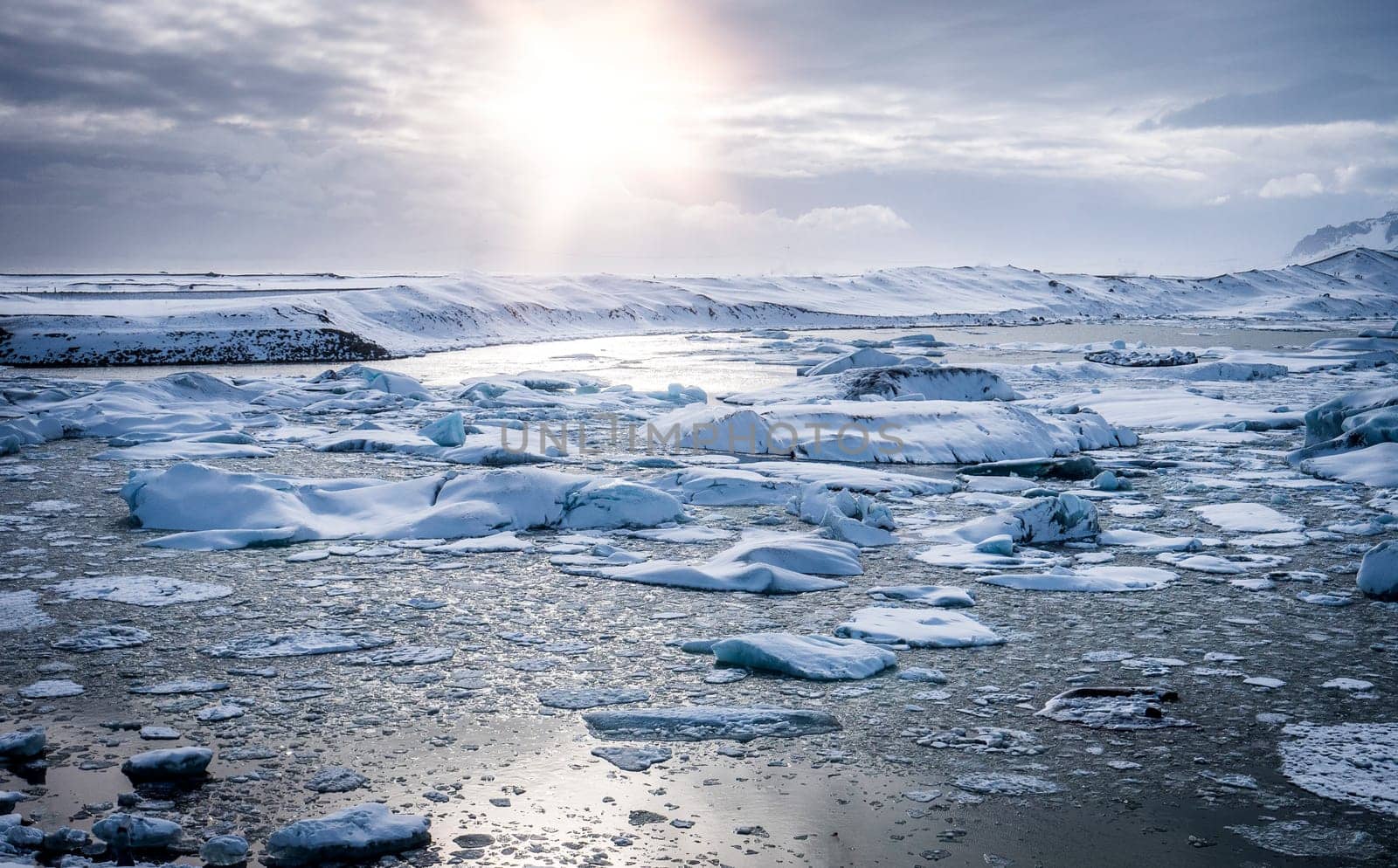 Cold sea water splashing near icy coast in beautiful winter evening in Iceland