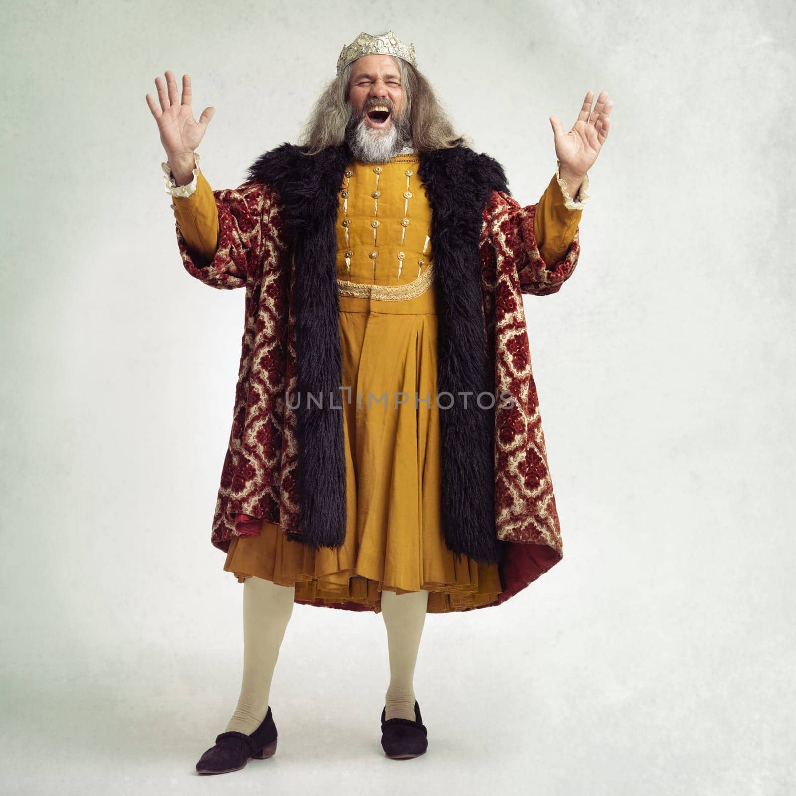 Ancient king man, screaming and studio with laugh, funny and renaissance fashion by backdrop. Medieval royal leader, clothes and laughing with crown, happiness and robe for power, success and luxury by YuriArcurs