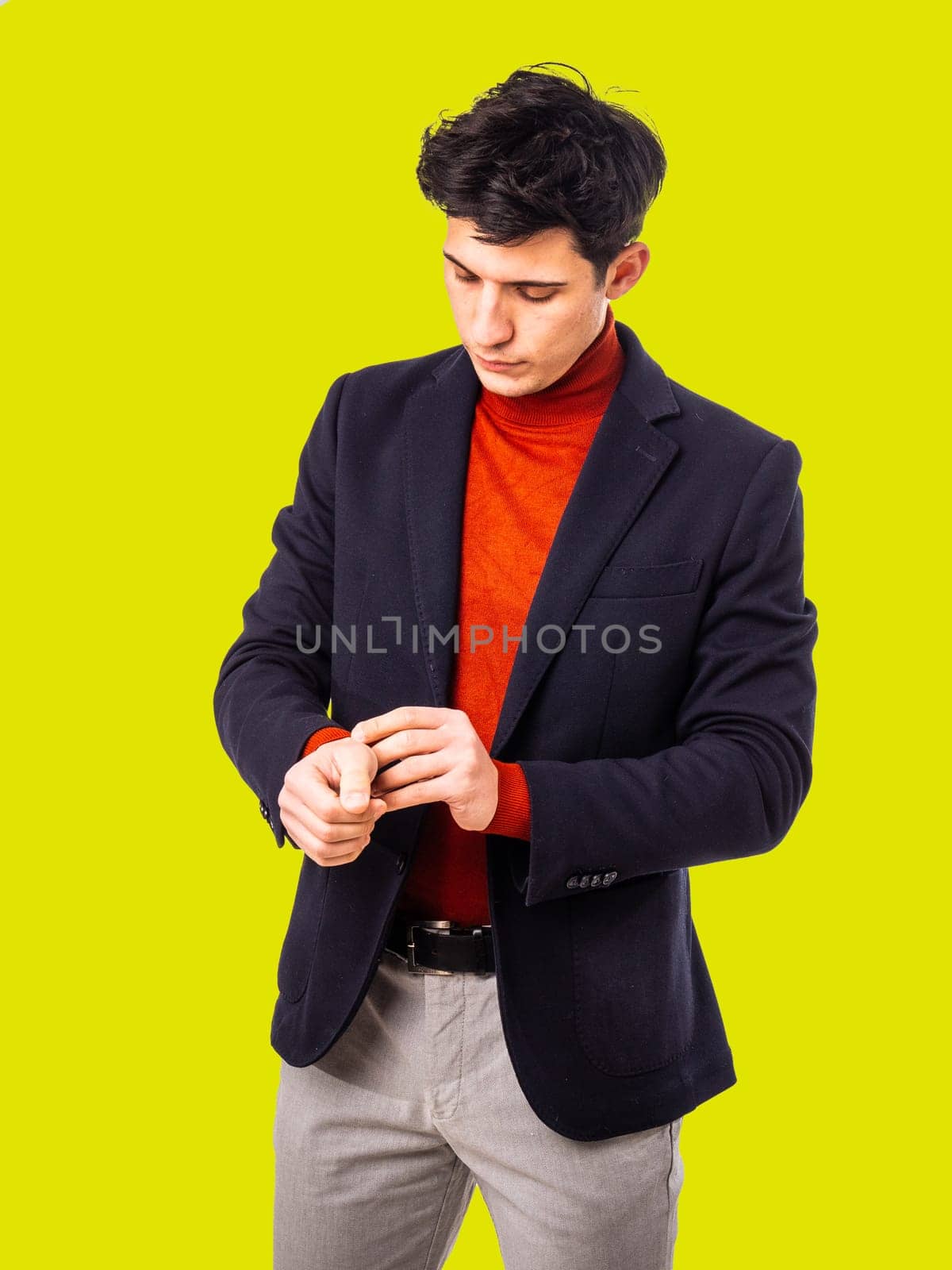 Handsome young man in studio, adjusting his jacket by artofphoto